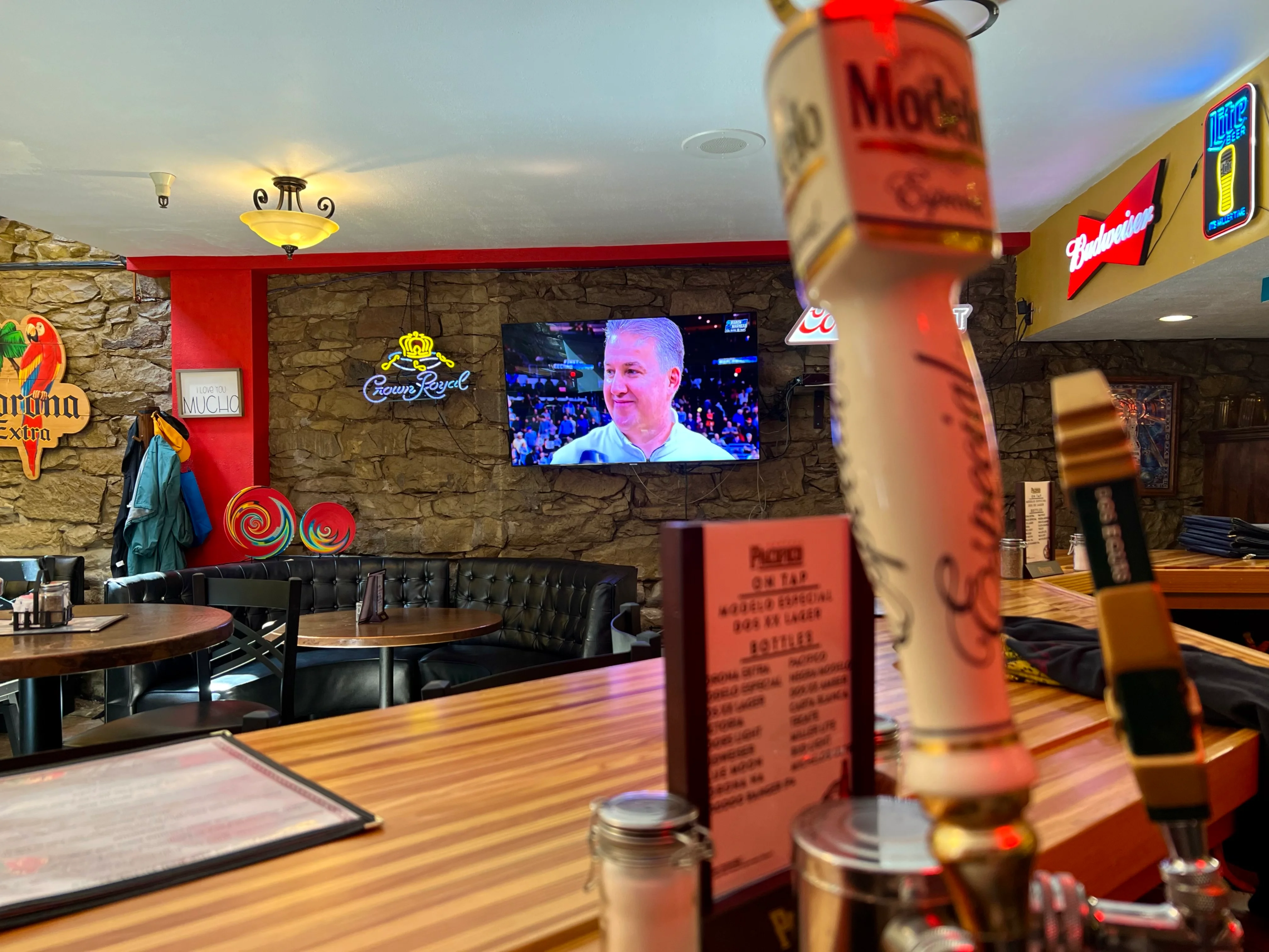 Cozy bar interior with neon signs and a TV screen