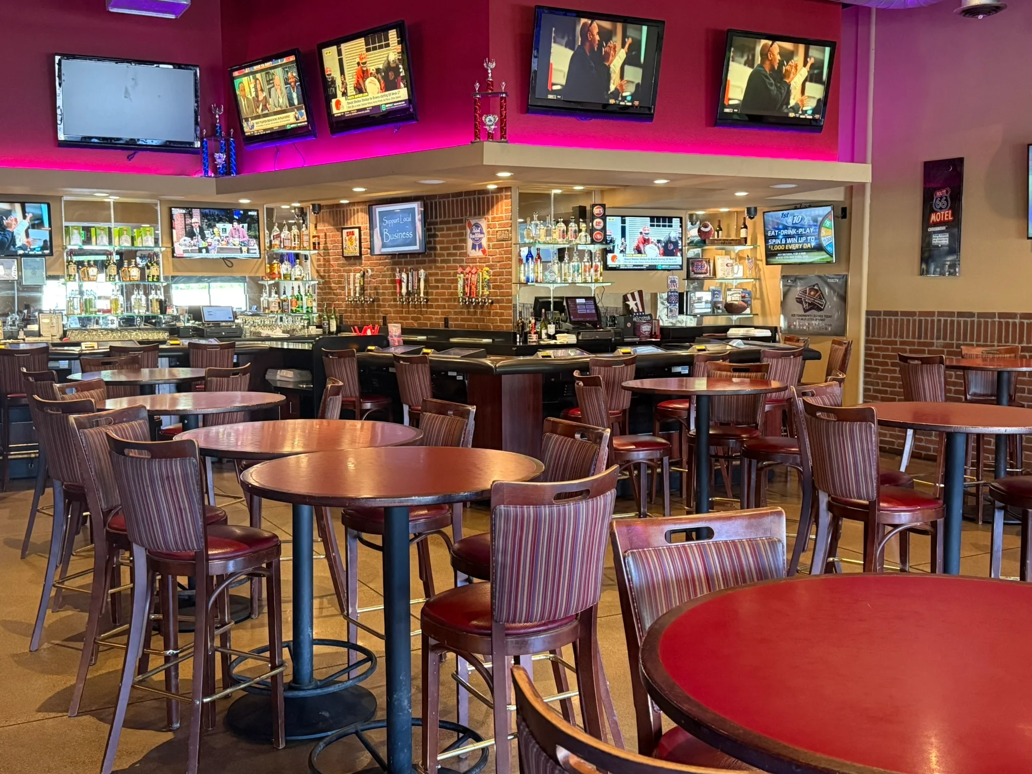 Cozy bar interior with wooden tables and multiple TVs