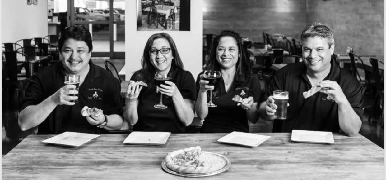 Group enjoying pizza and drinks in a cozy restaurant setting