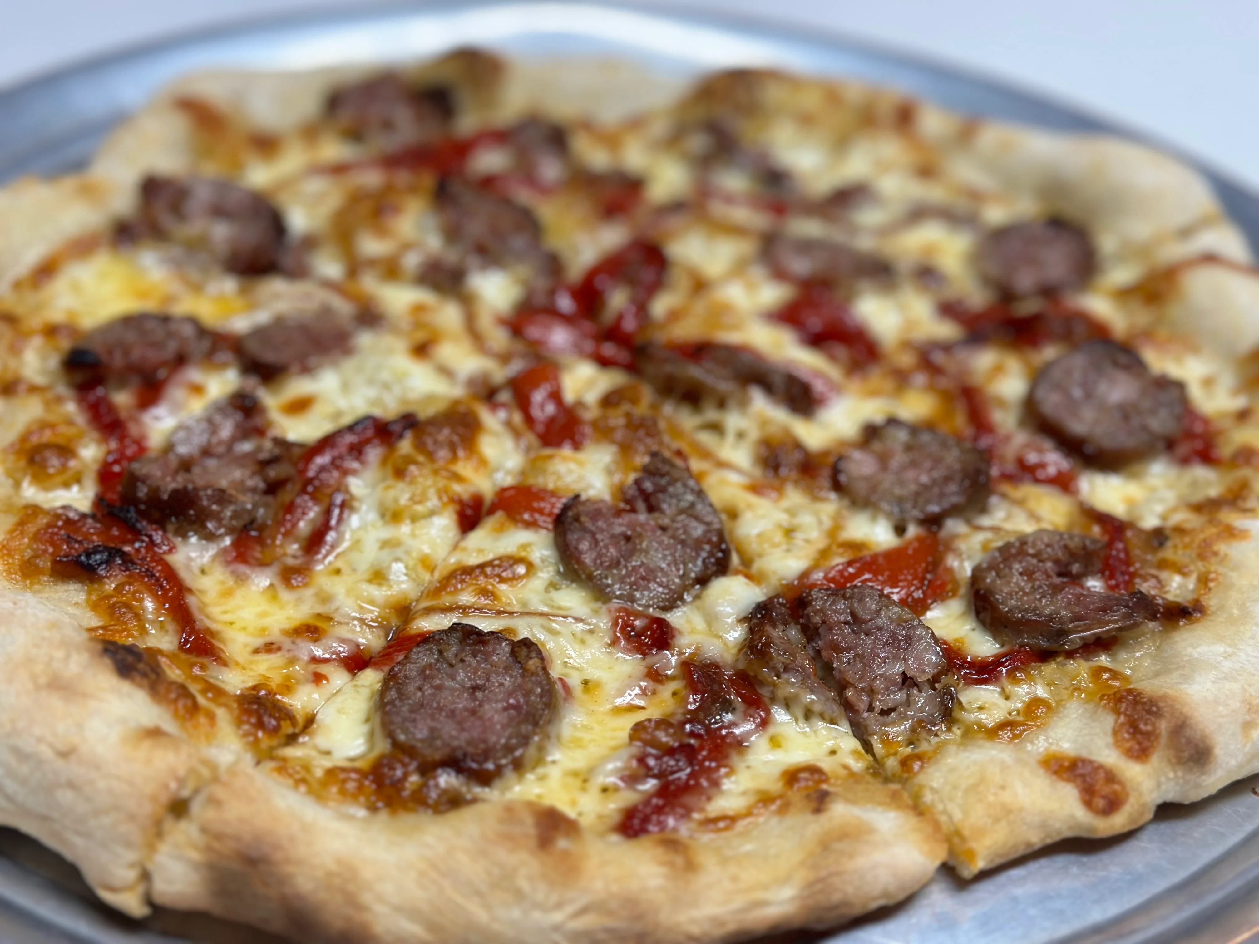Italian sausage pizza with roasted red peppers