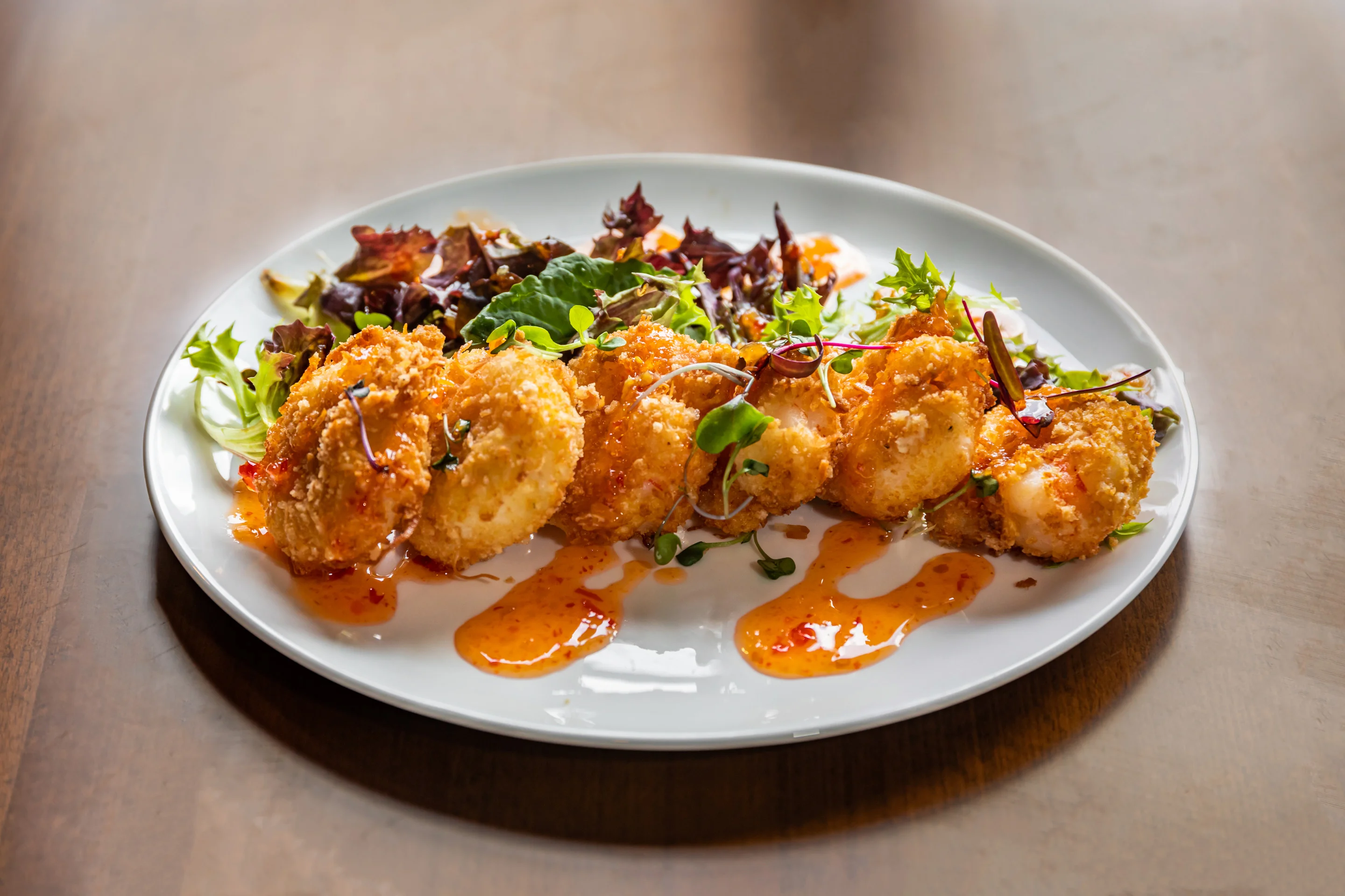 Crispy shrimp tempura with spicy sauce and fresh greens