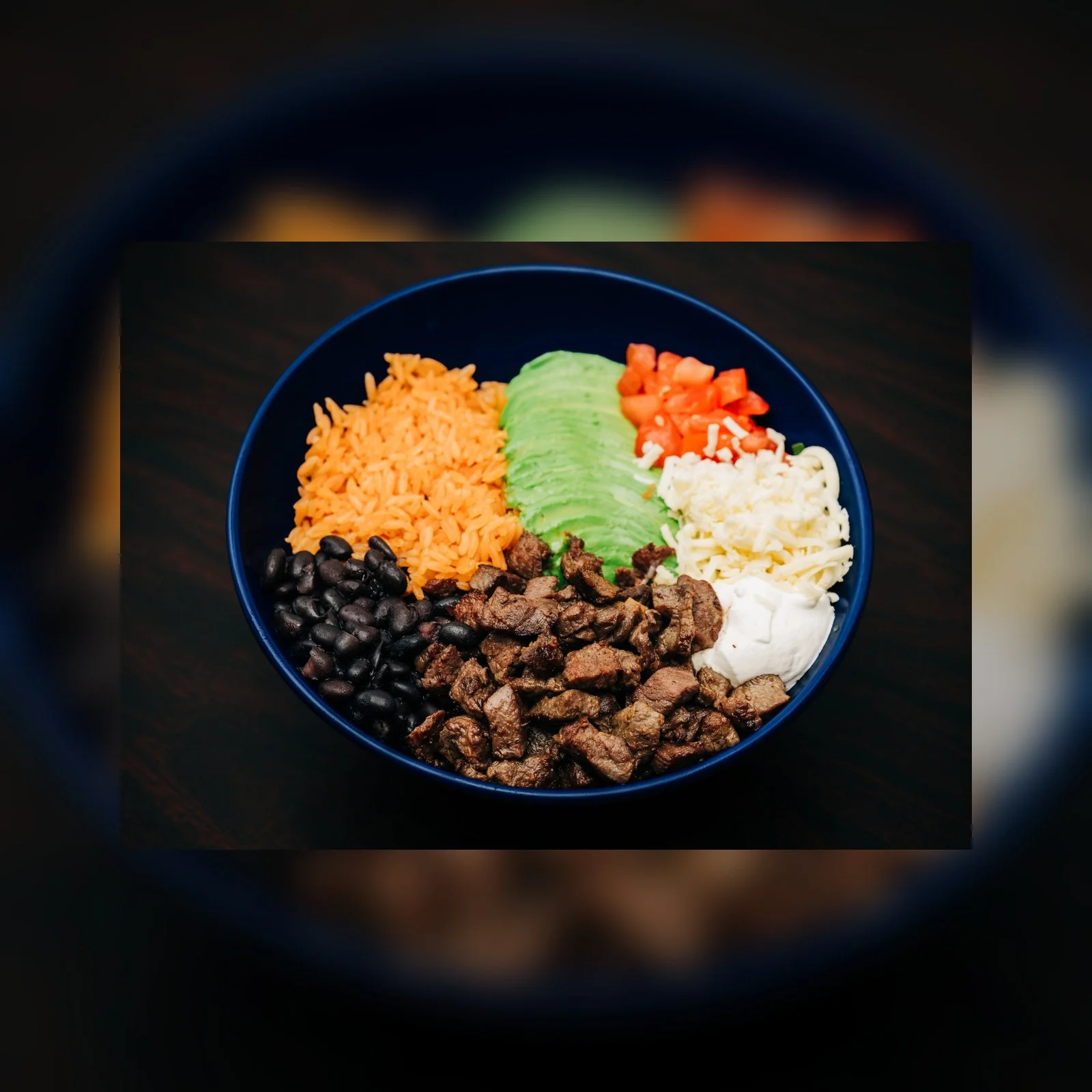 Colorful Mexican burrito bowl with steak, rice, and fresh toppings