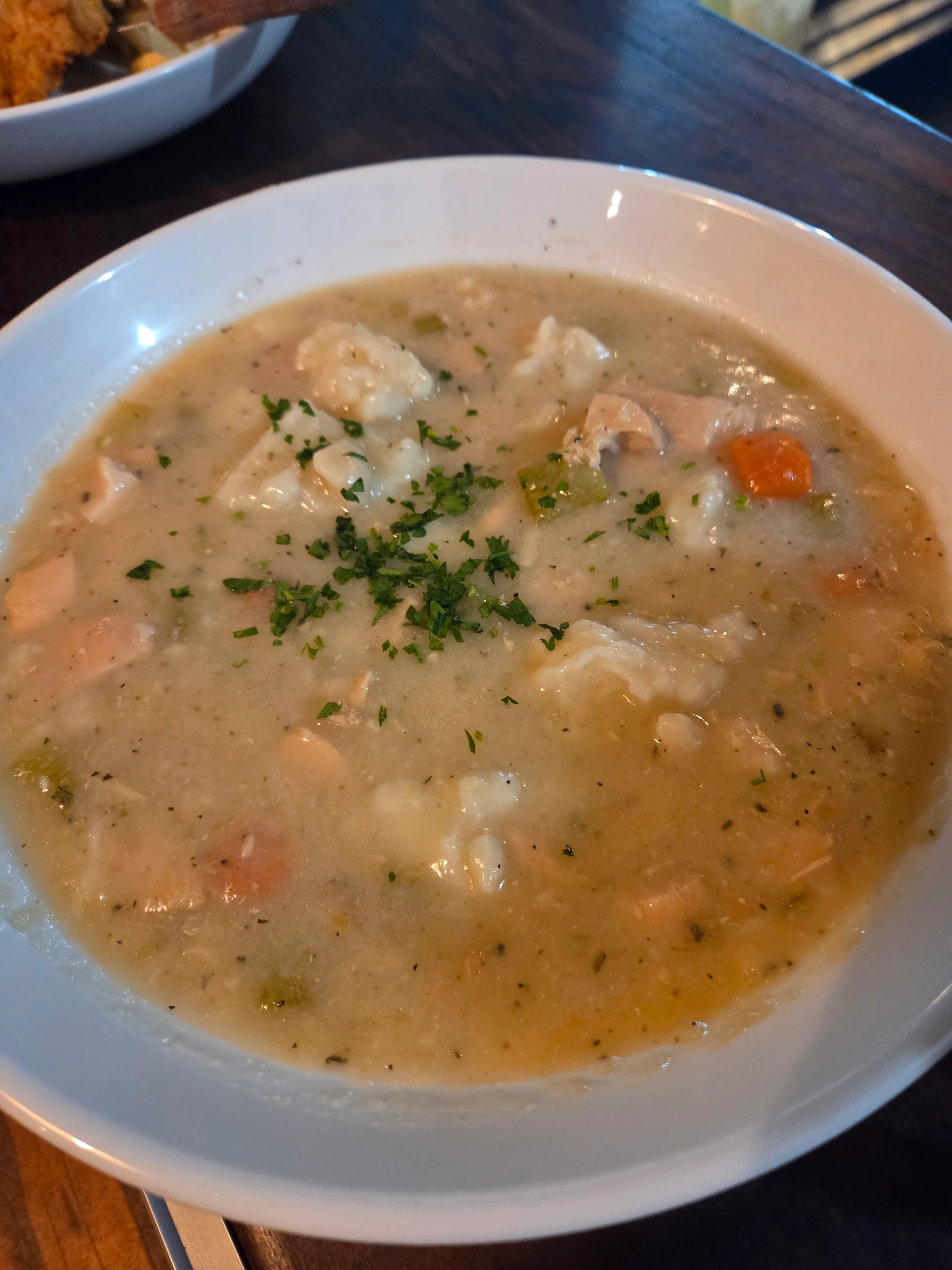 Bowl of chicken and dumplings in creamy broth