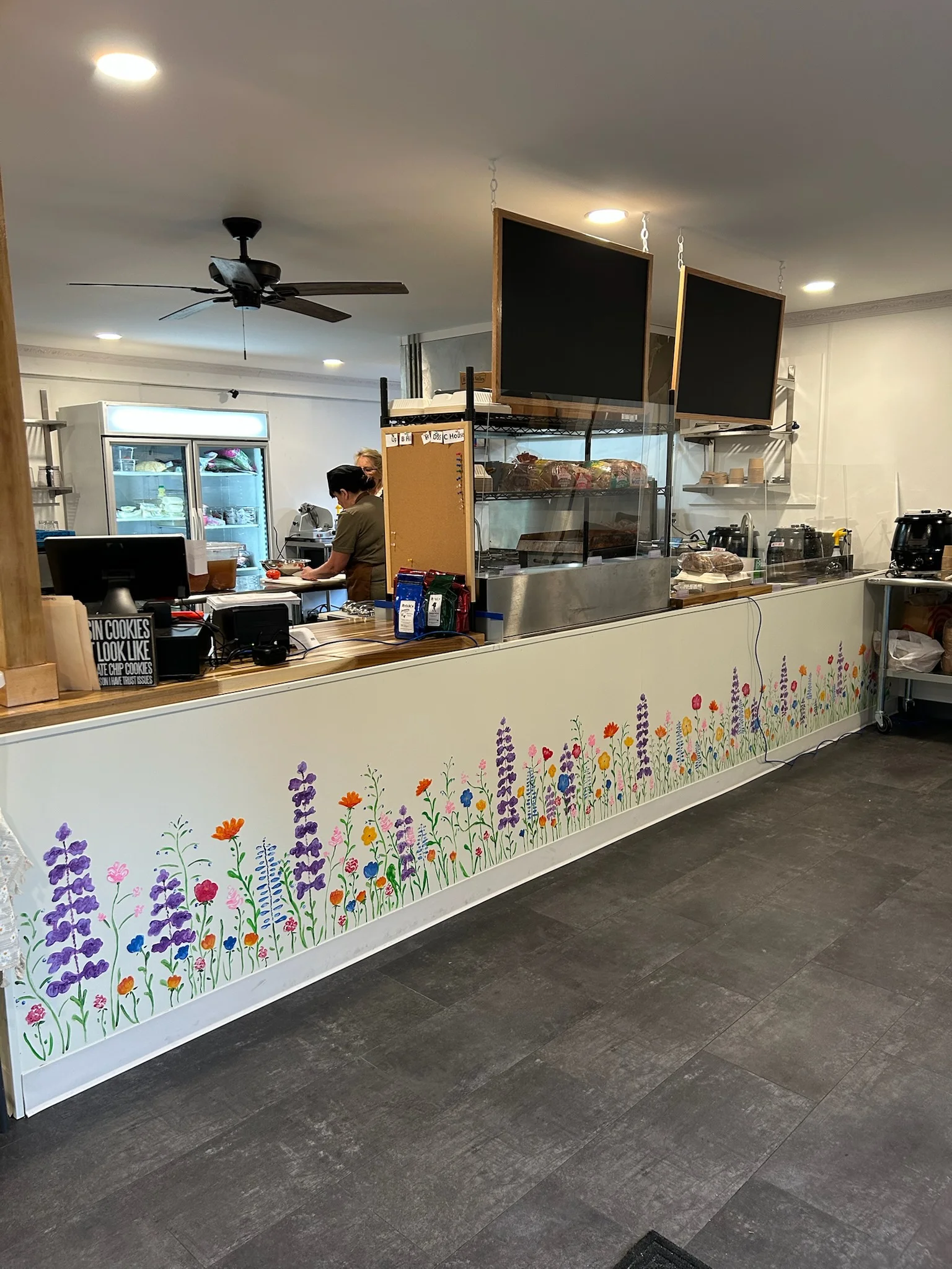Cozy café interior with floral mural and open kitchen