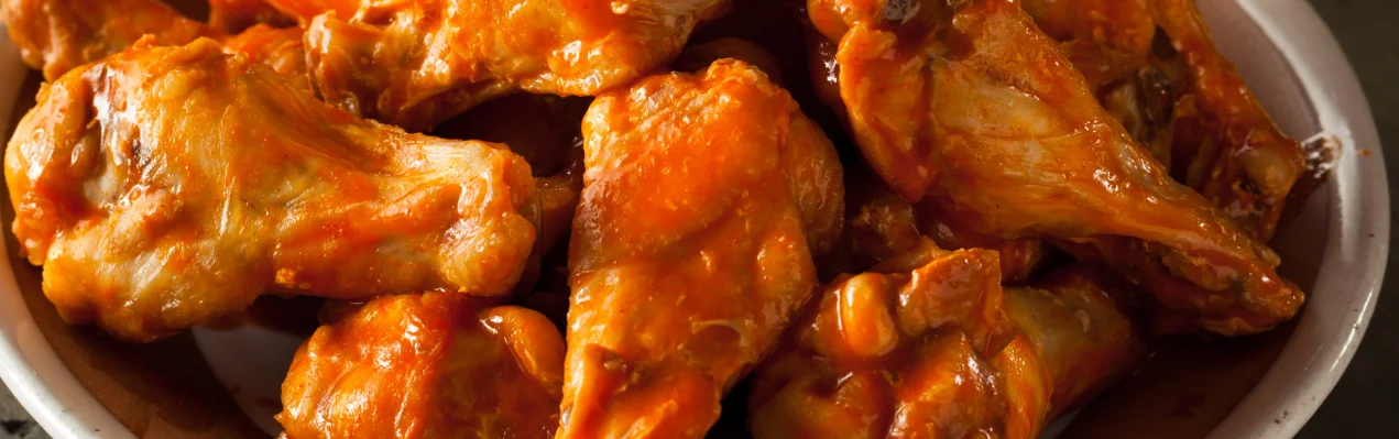 Plate of spicy Buffalo chicken wings with dipping sauce