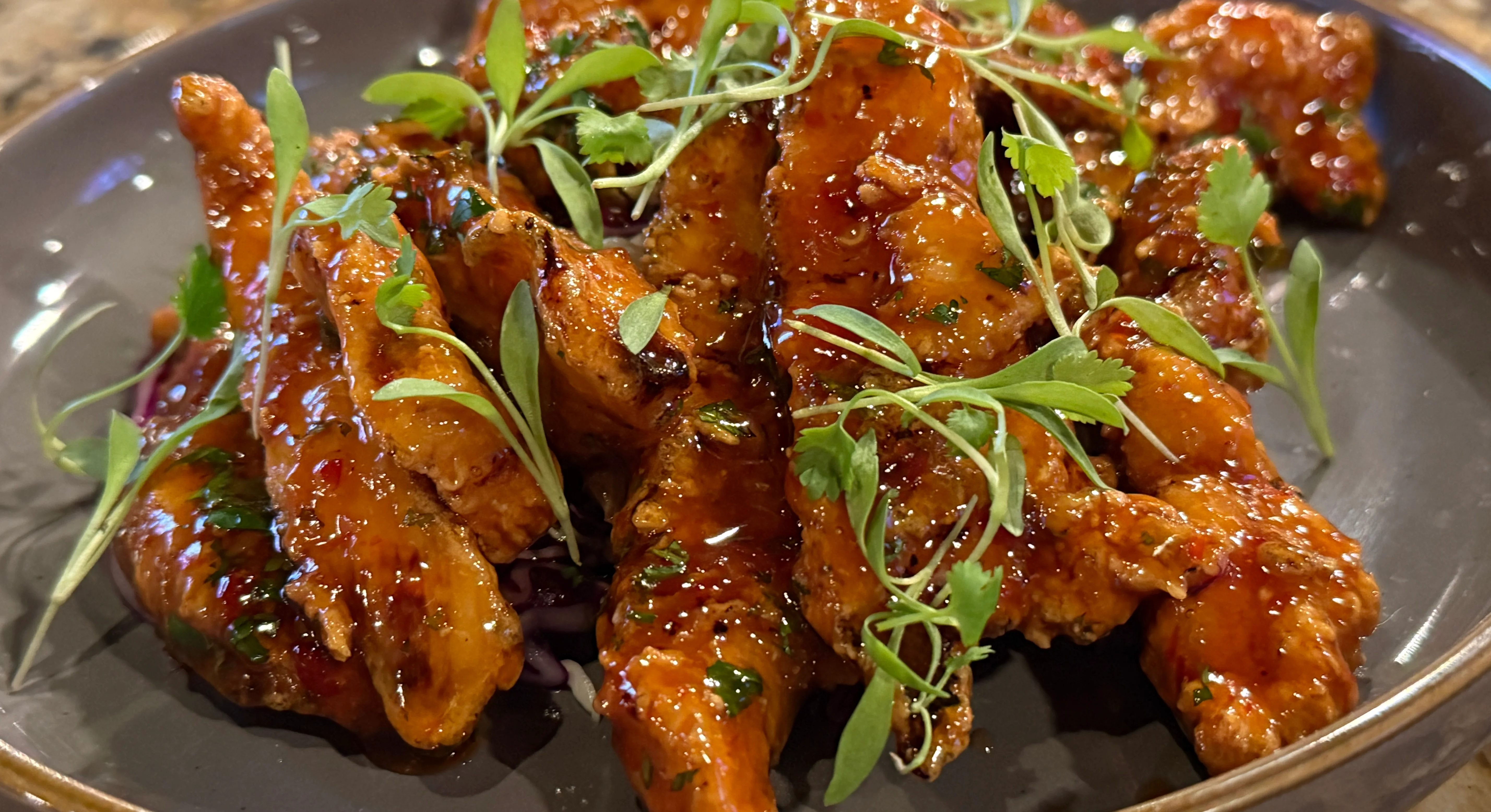 Sweet and spicy Korean chicken strips garnished with herbs