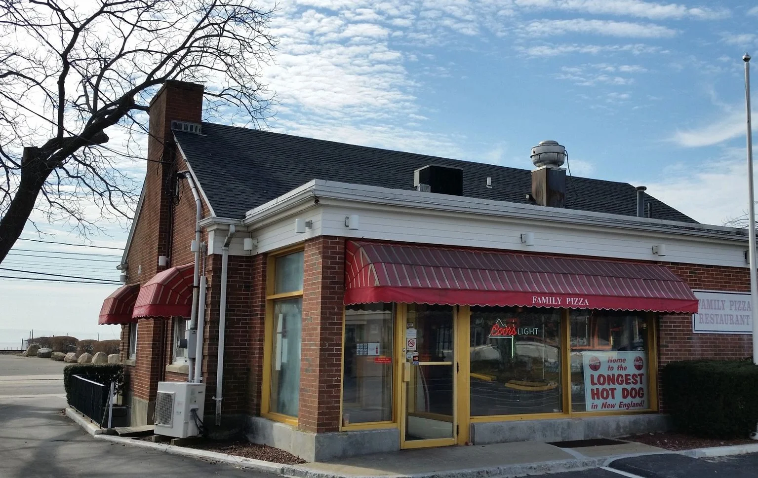 Charming family pizza restaurant exterior with red awnings