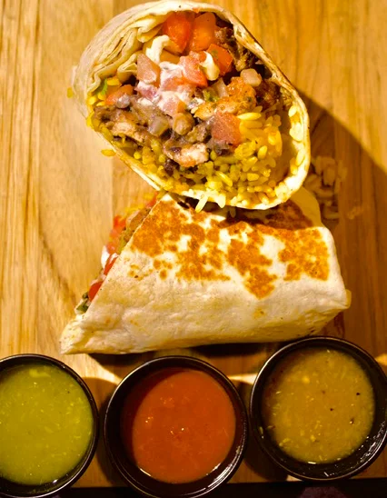 Delicious burrito with beans and rice served with salsas