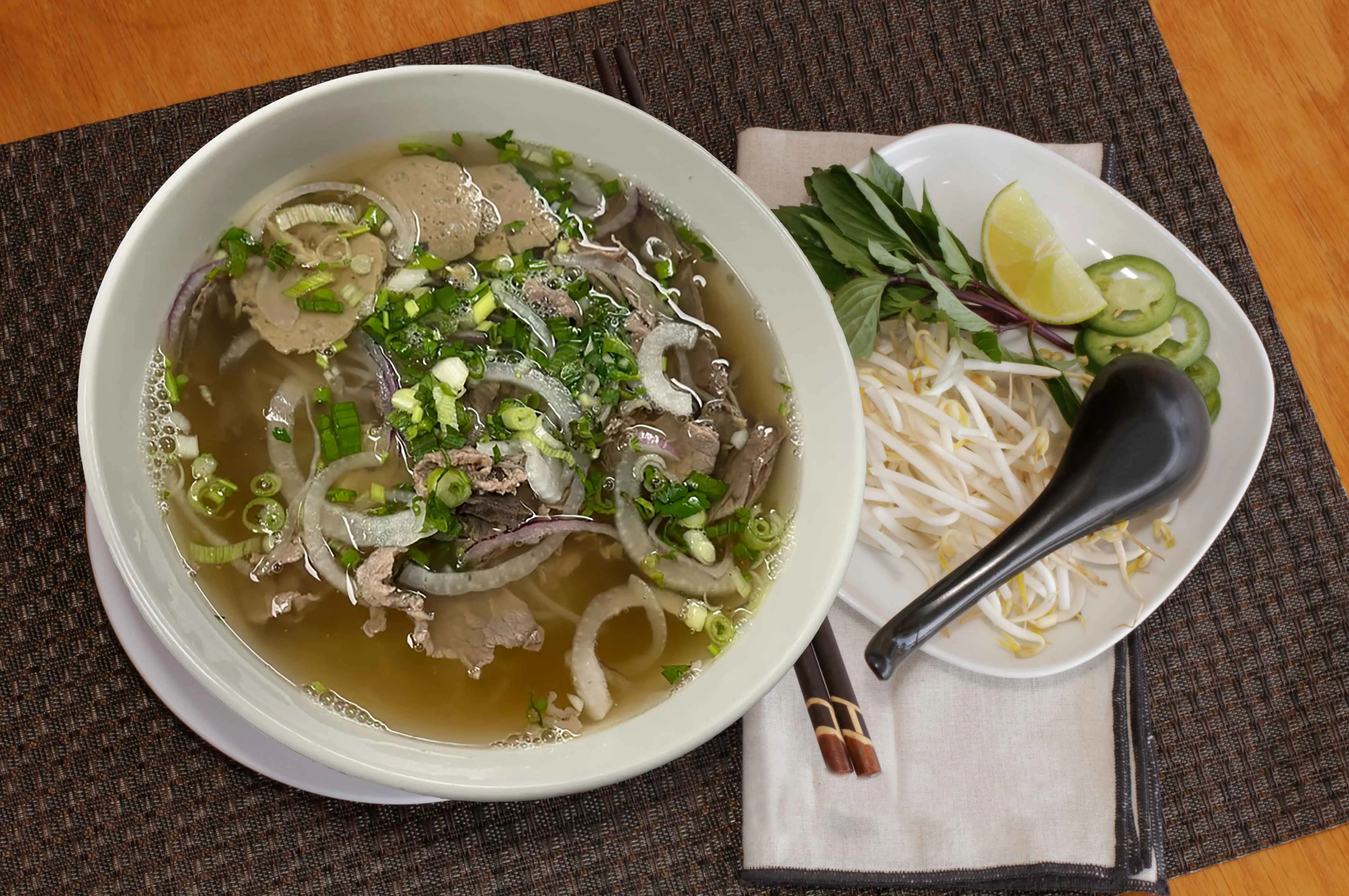 Bowl of Vietnamese pho with beef and fresh herbs