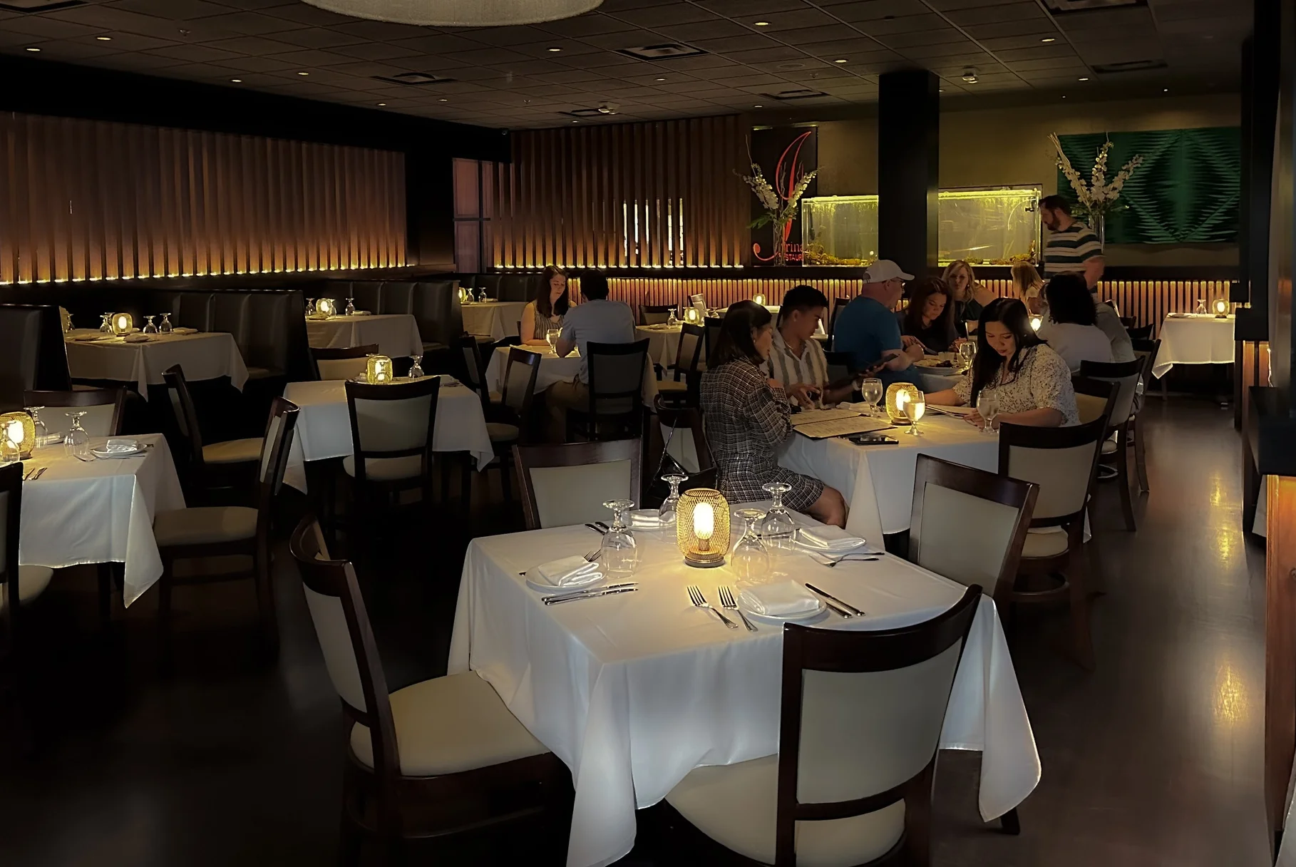 A look at the bustling dining room of Irina's Steak & Seafood, where people are gathered for a meal and conversation.