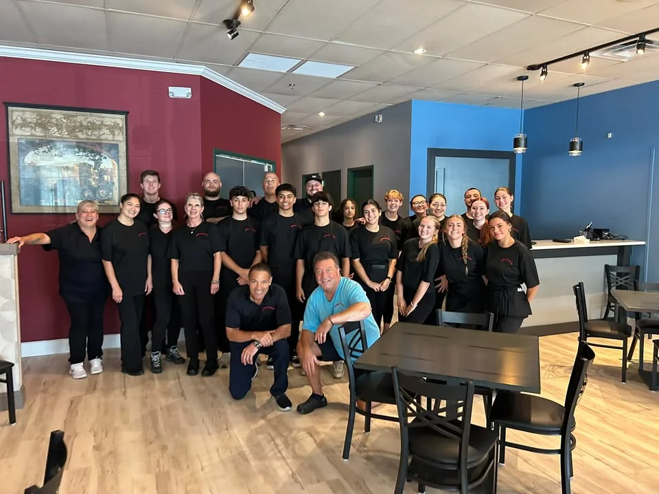Restaurant staff posing together in a vibrant dining area
