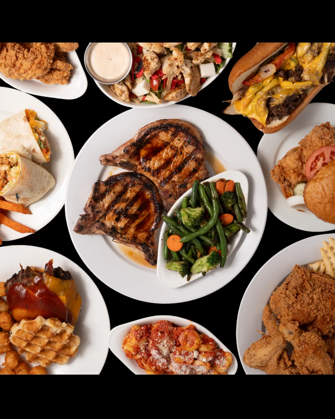 Assorted American comfort food platter with grilled meats and sides