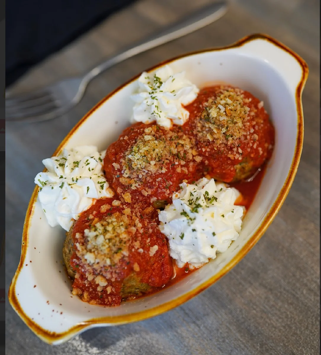 Italian meatballs in marinara sauce with whipped cream