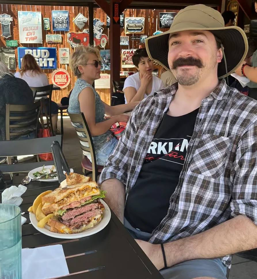 Giant cheeseburger with fries in a casual restaurant setting