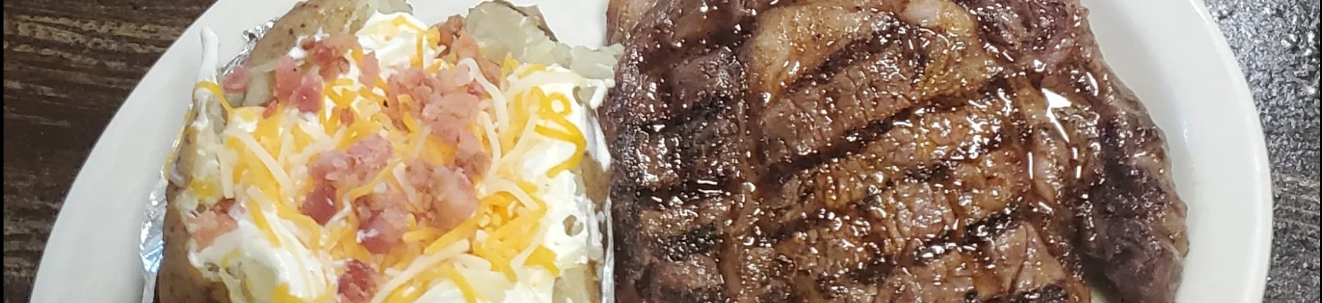 Grilled steak with loaded baked potato