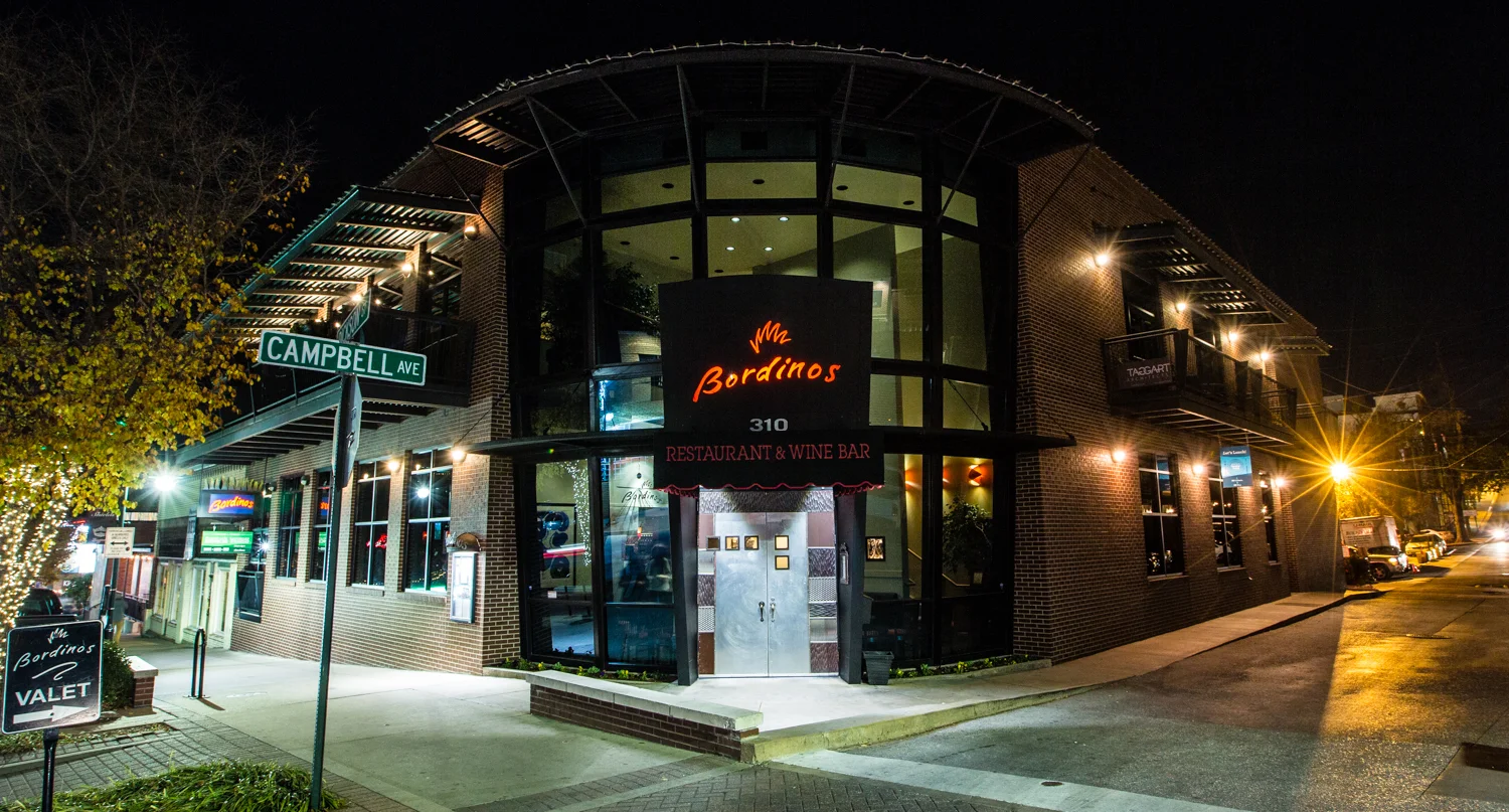 Modern restaurant exterior at night with warm lighting