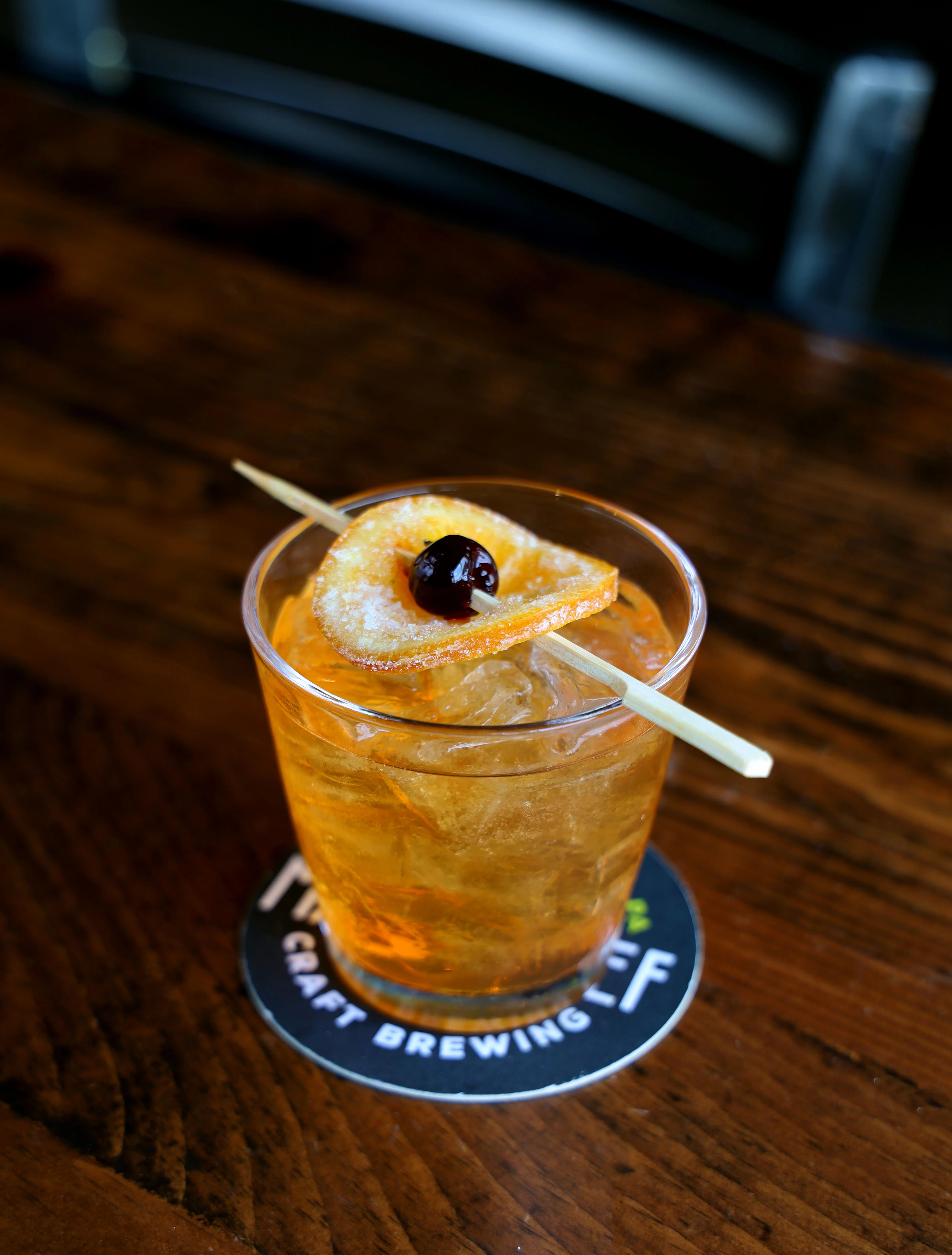 Refreshing cocktail with ice and garnish on a wooden table