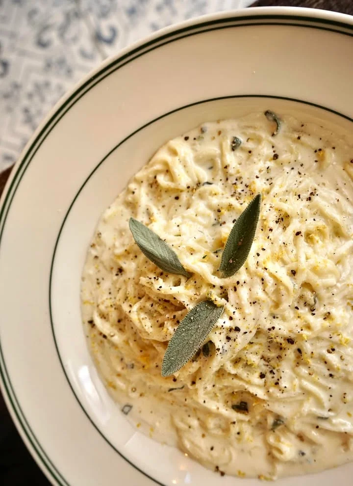 Creamy Italian fettuccine alfredo garnished with sage leaves