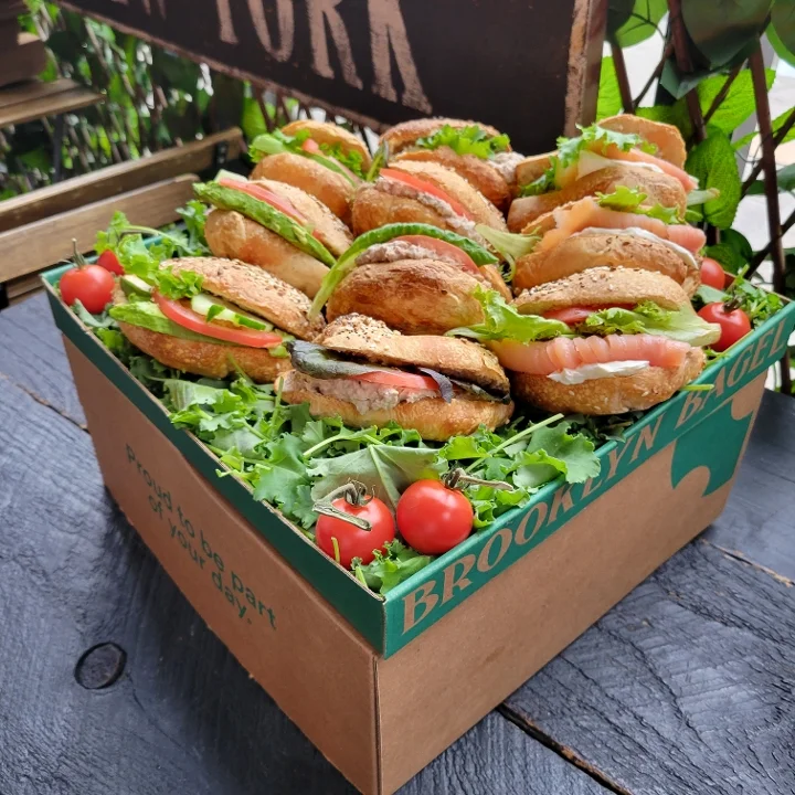 Assorted bagels with fresh toppings in a decorative box
