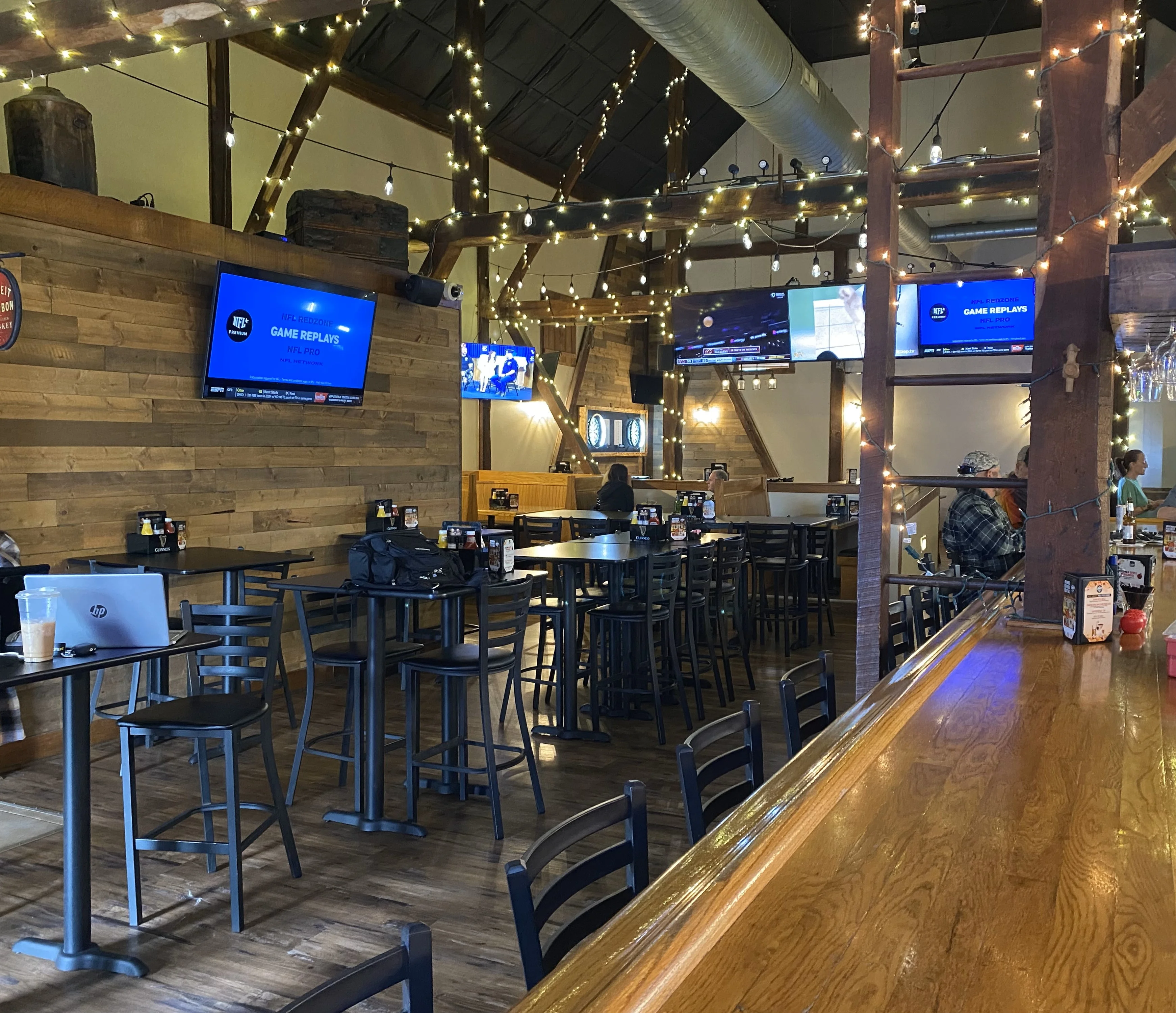 Cozy restaurant interior with wooden decor and TVs for sports viewing