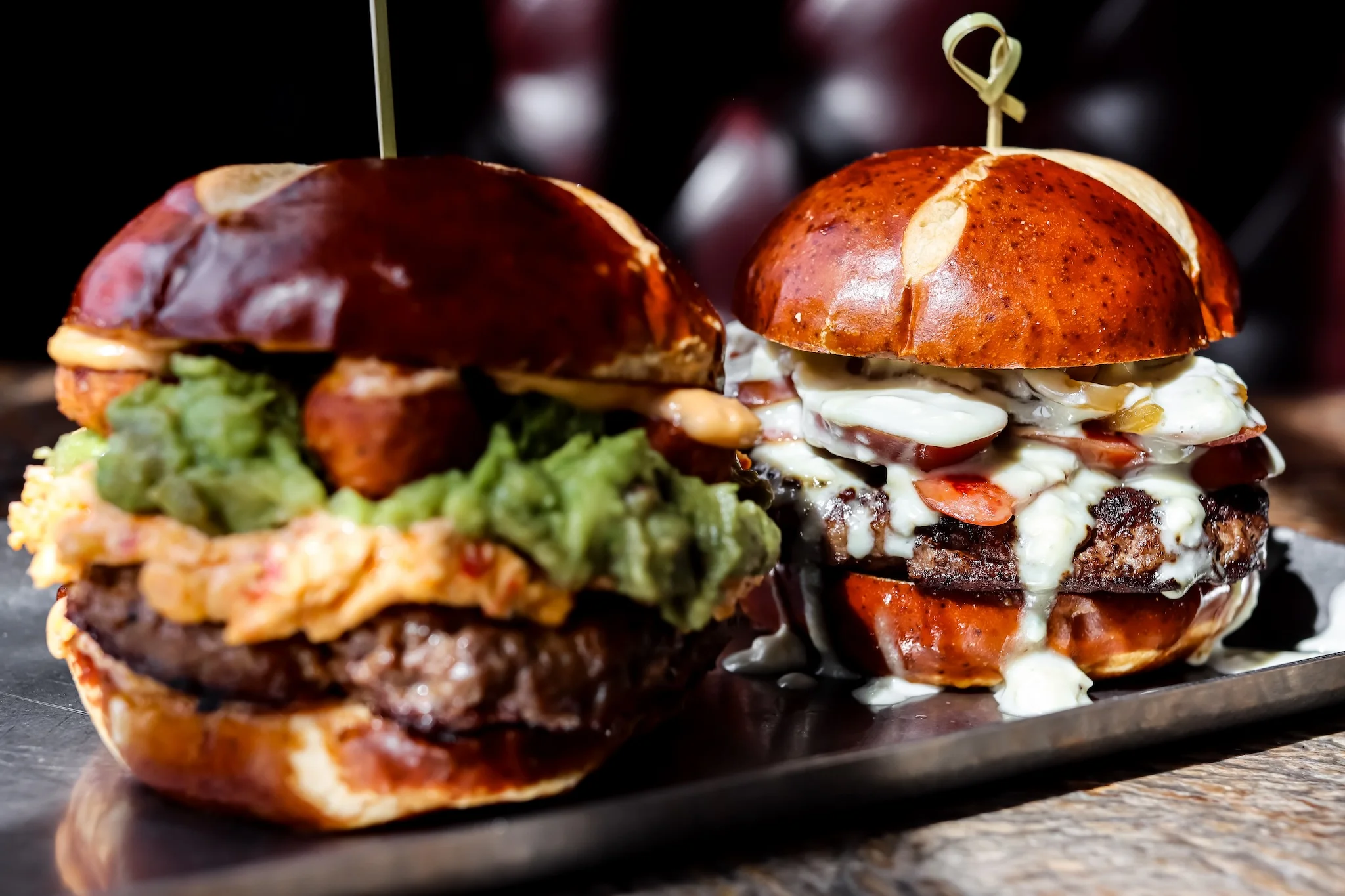 Gourmet burgers on pretzel buns with unique toppings
