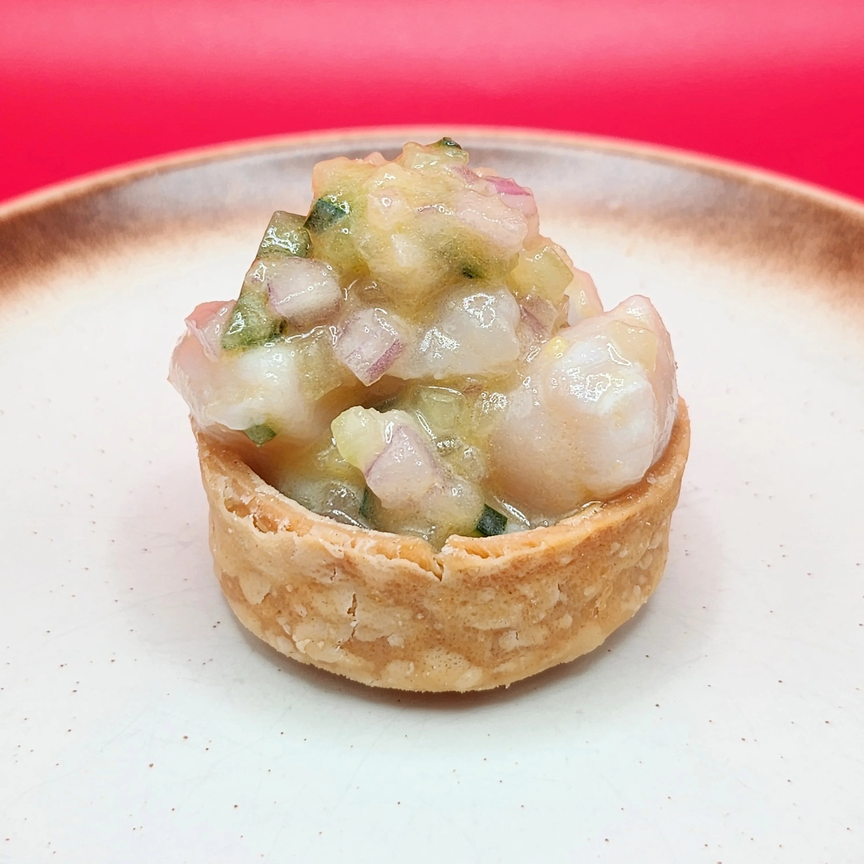 A vibrant plate of Bay Scallop Ceviche garnished with fresh herbs.