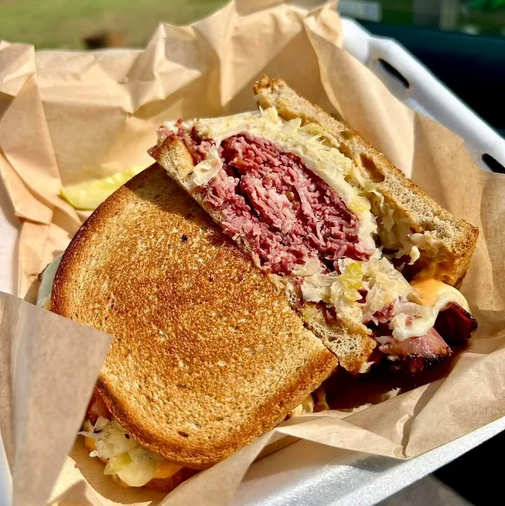 A hearty beef sandwich with melted cheddar cheese on a toasted bun, accompanied by crispy French fries.