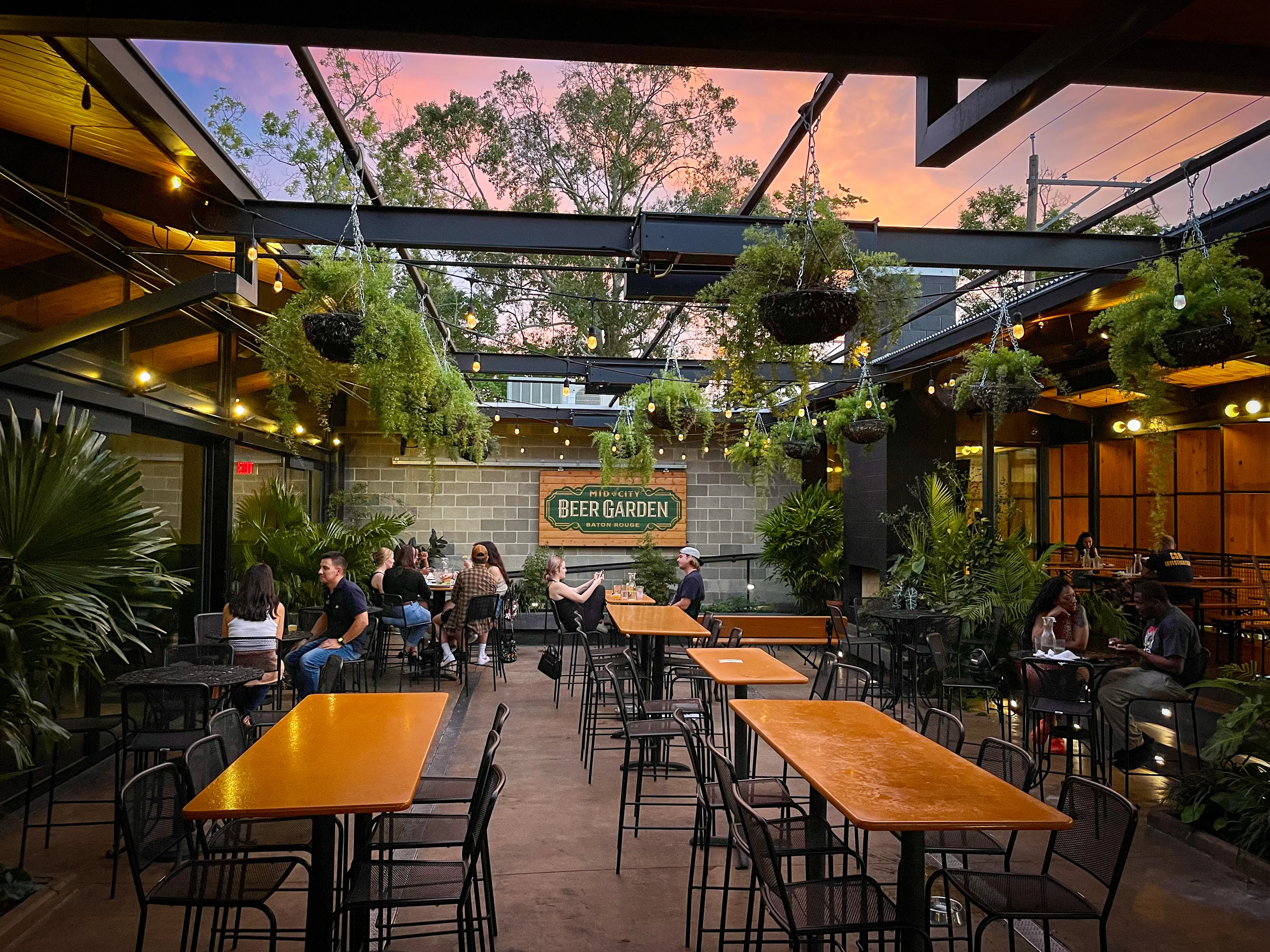 Stylish beer garden with outdoor seating and sunset sky