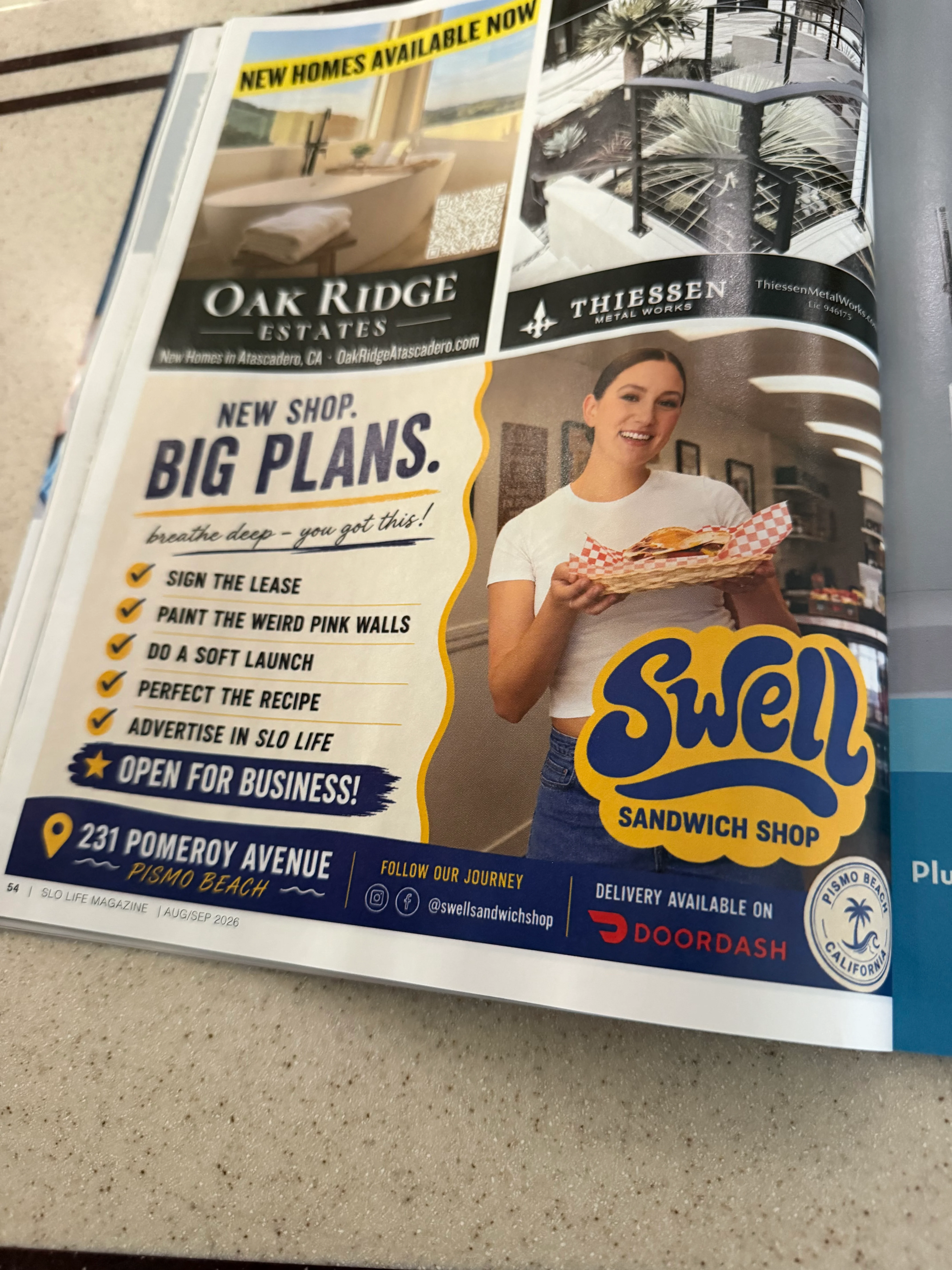 Welcoming sandwich shop interior with a smiling staff member holding a sandwich