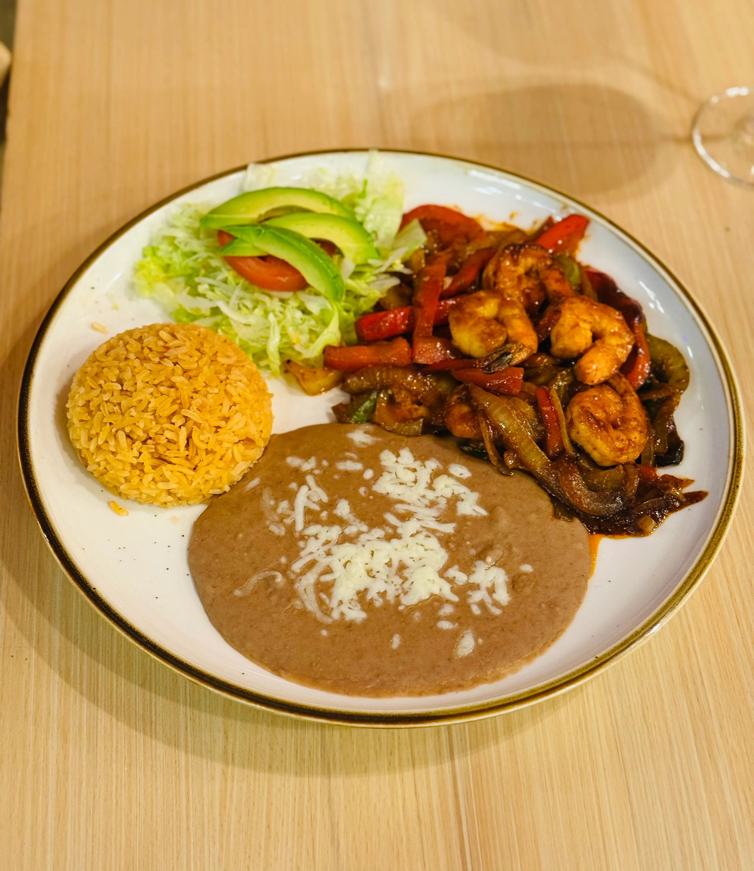 Shrimp fajitas with rice and beans on a vibrant plate