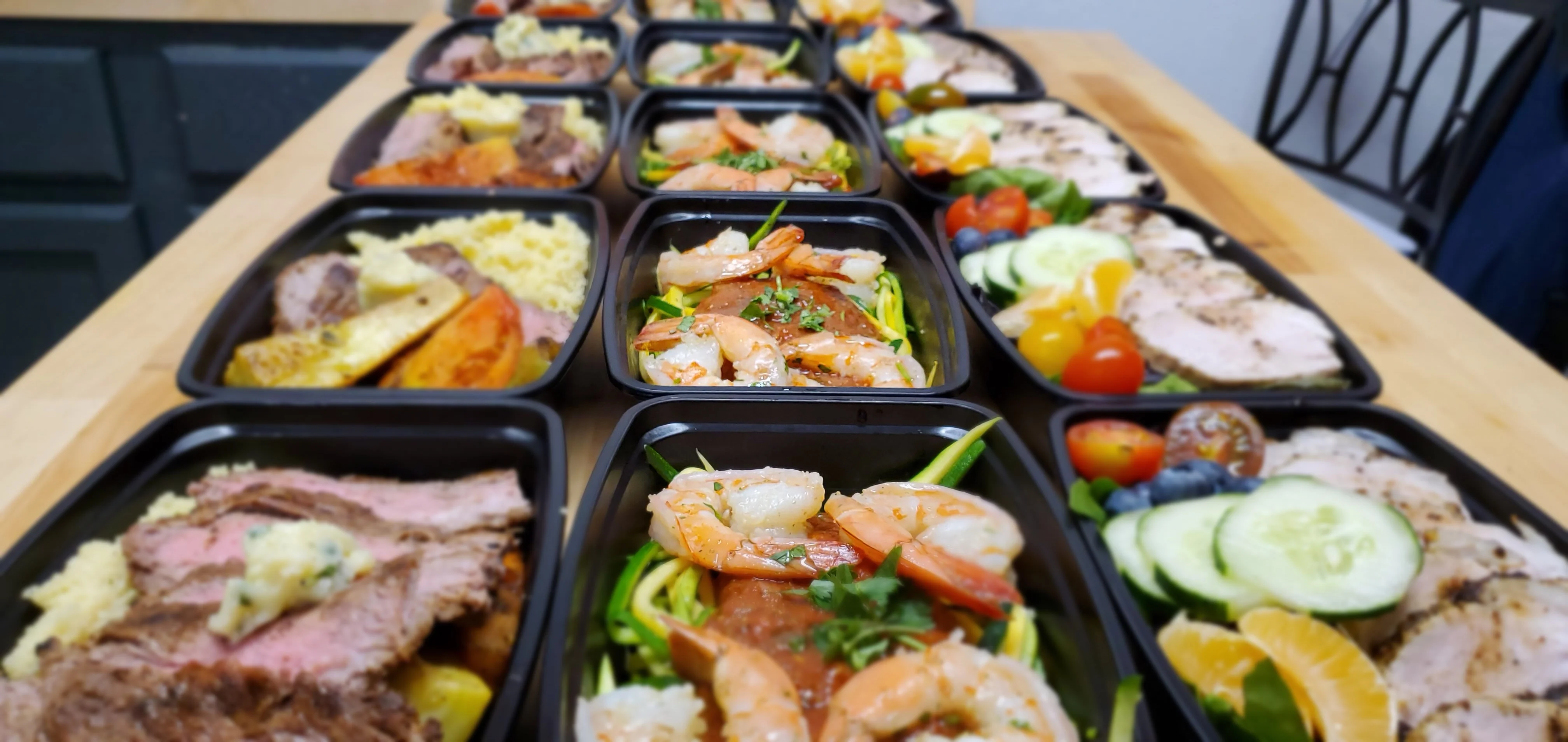 Assorted meal prep containers with shrimp and grilled meats