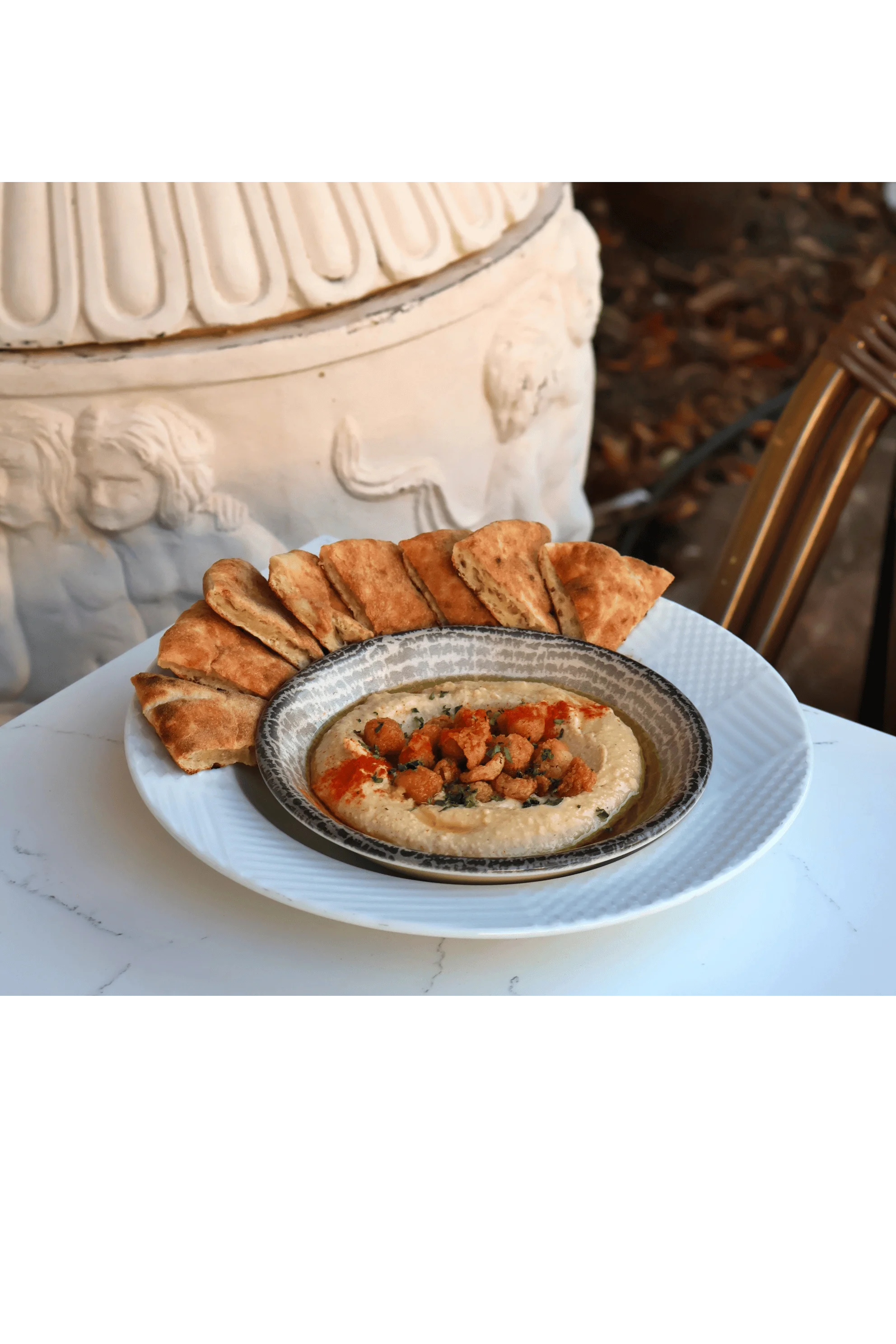 Hummus topped with spiced cauliflower and pita bread