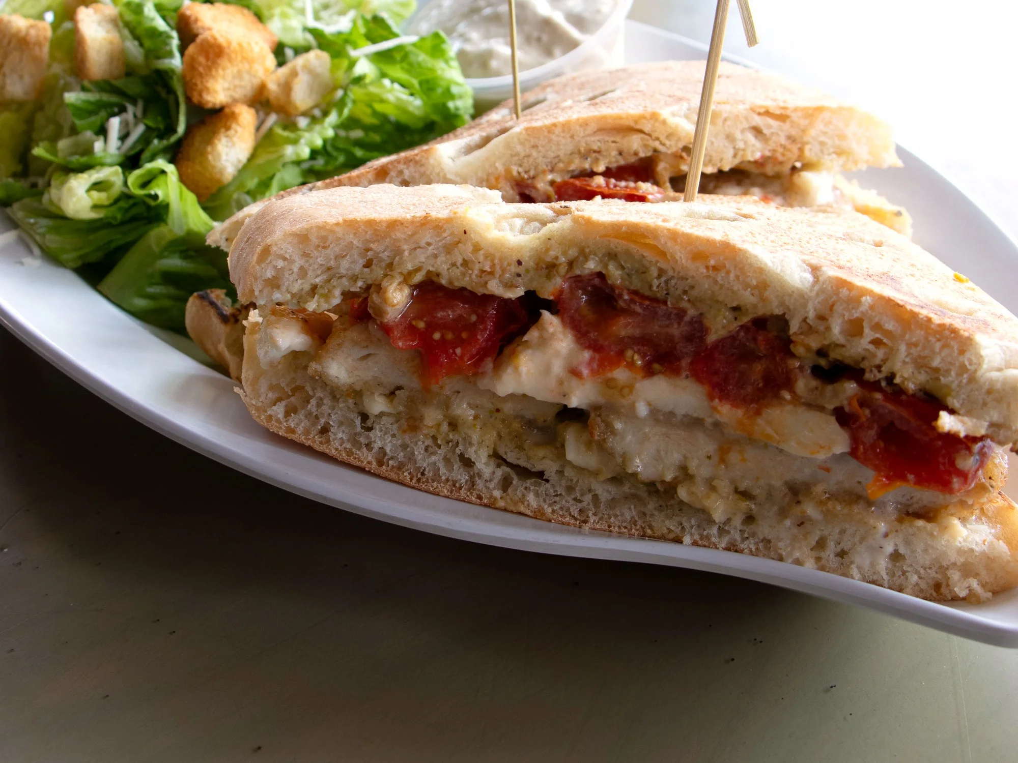 The Sofia panini at Naples Flatbread: air-fried chicken cutlet, stracciatella, blistered tomato and pistachio pesto crema on focaccia