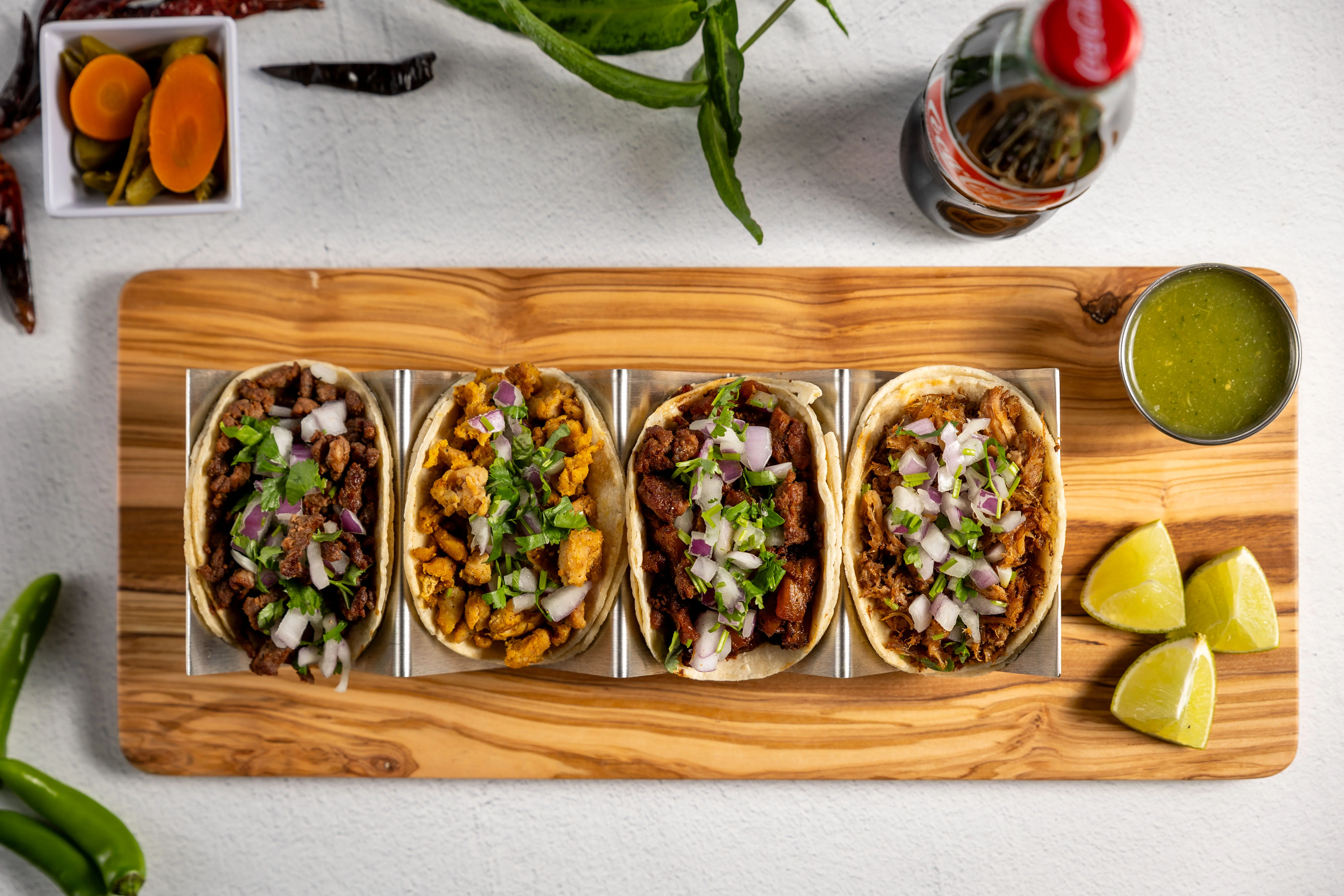 Delicious tacos served on a wooden table with fresh toppings.