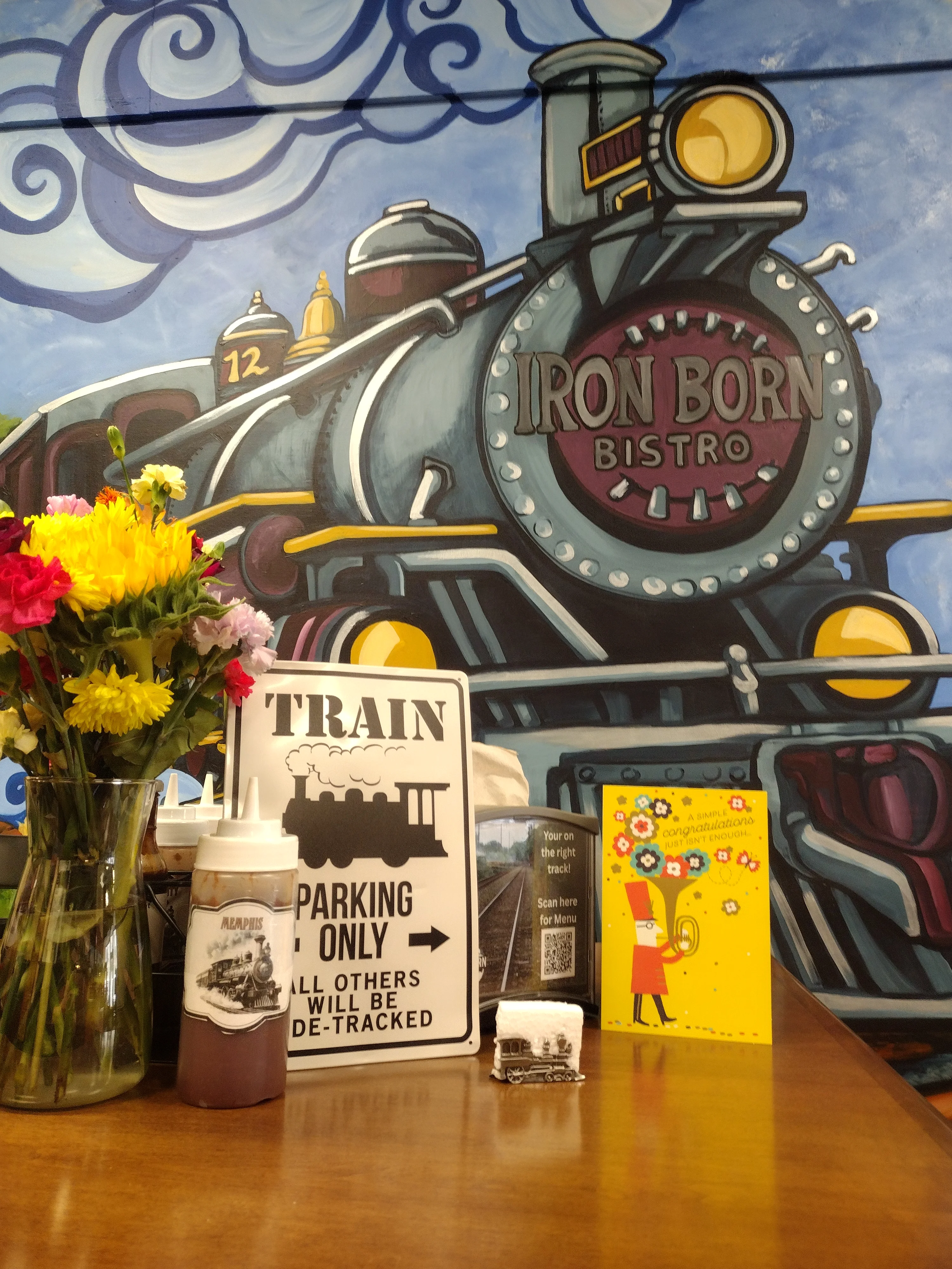 Cozy bistro interior with train mural and floral arrangement