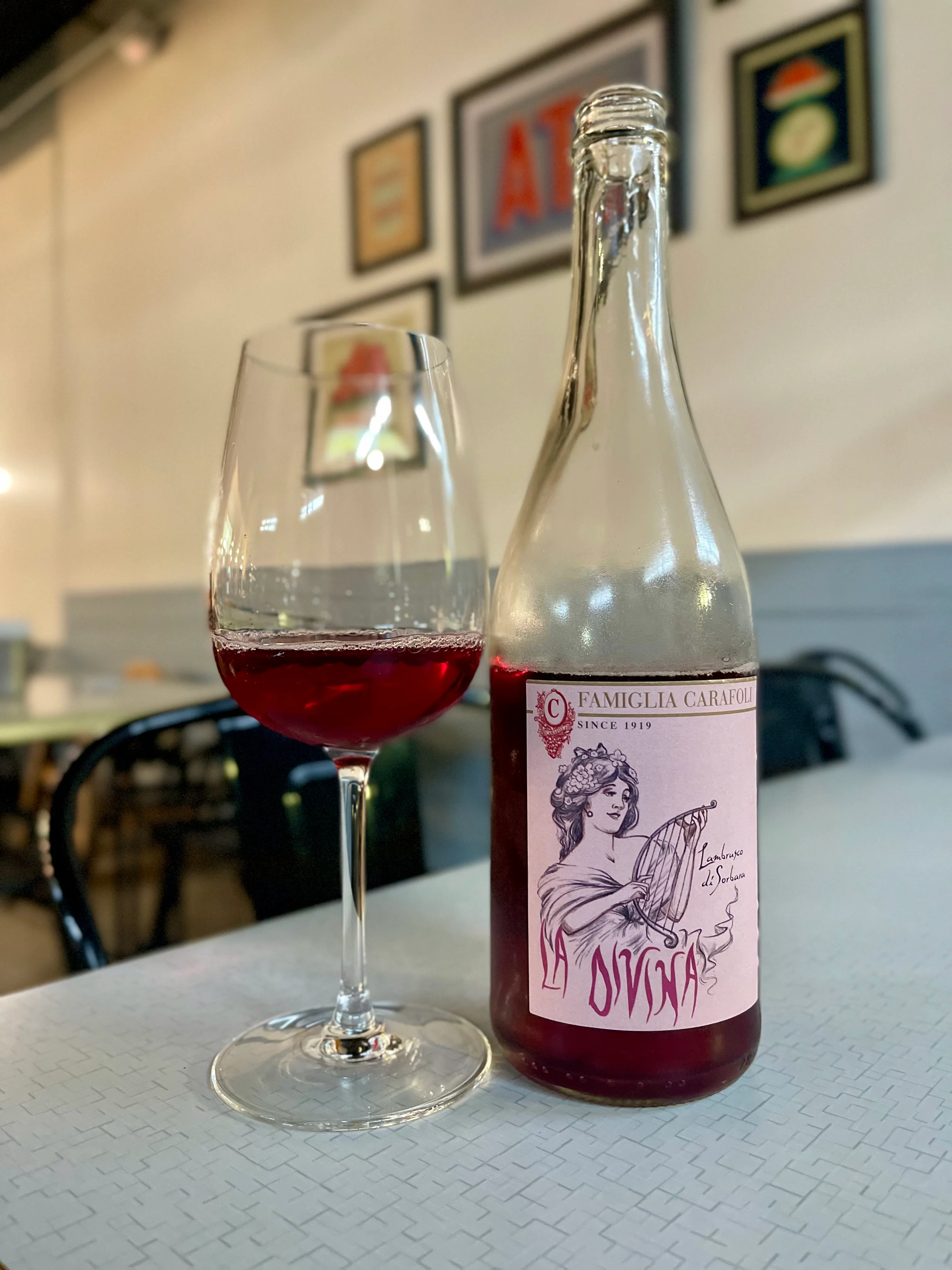 Bottle of La Divina wine with a glass in a cozy restaurant setting