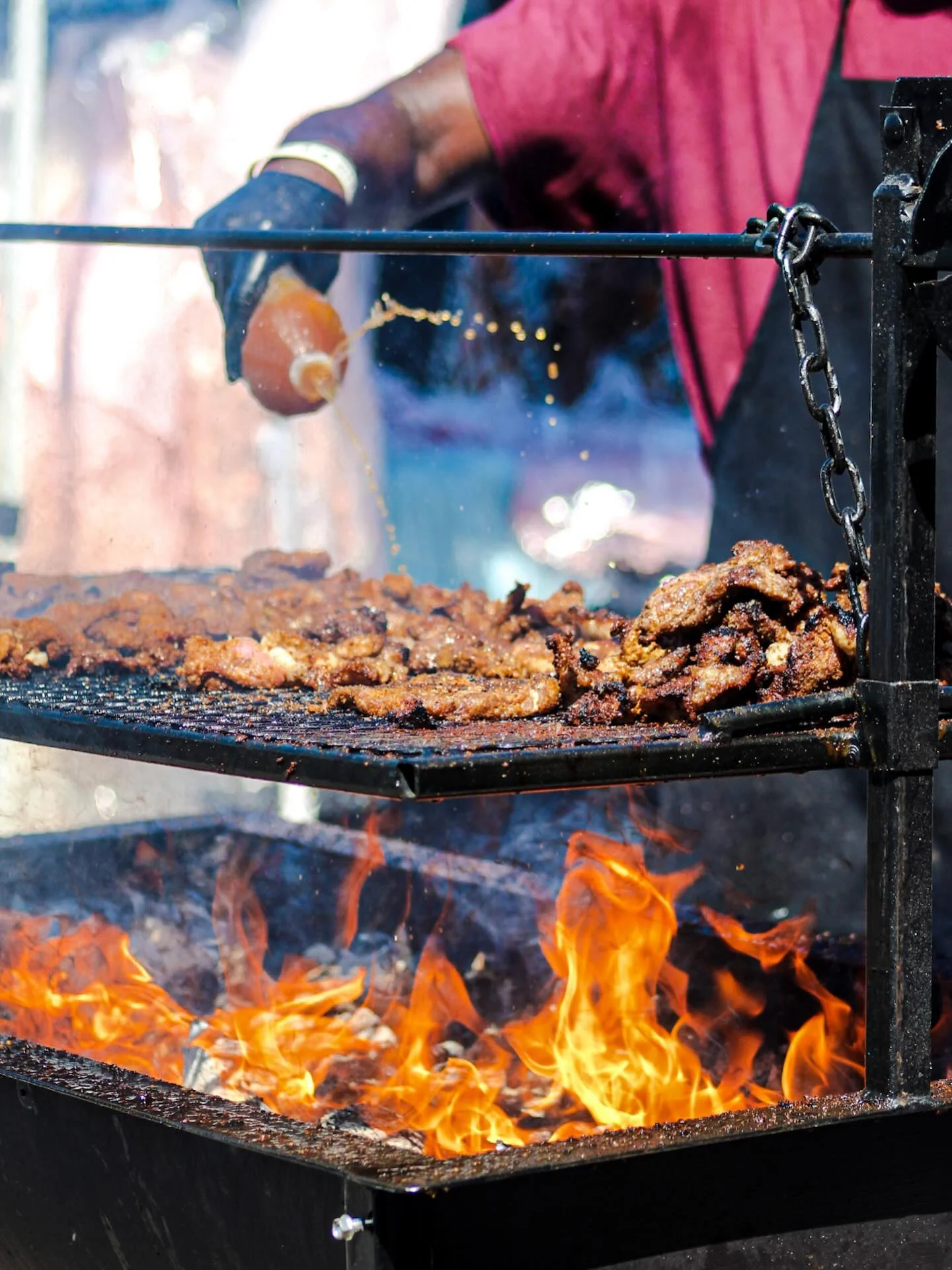 Grilled barbecue meats sizzling over an open flame