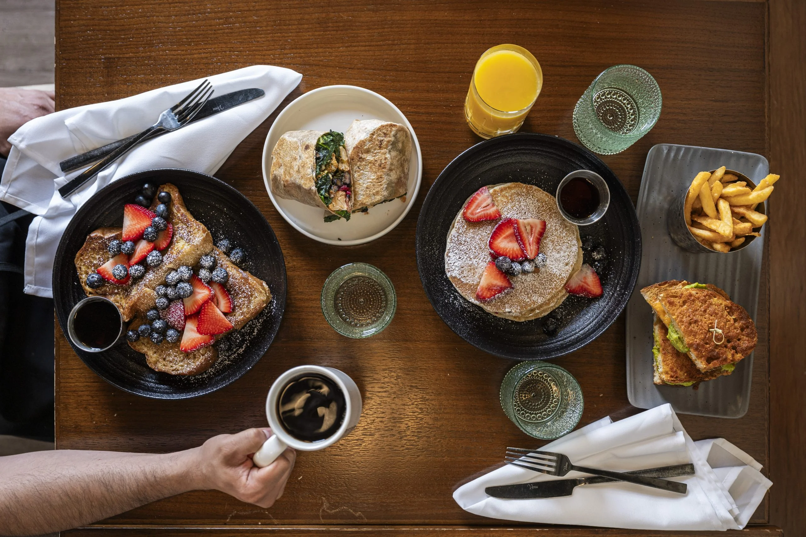 A delicious brunch spread with pancakes, French toast, and a wrap.