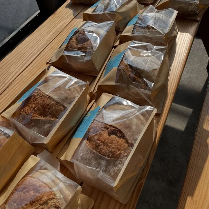 A display of individually wrapped bread packages arranged neatly on a wooden surface.
