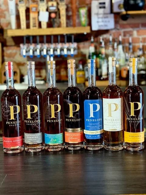 Selection of Penelope bourbon bottles on a bar counter