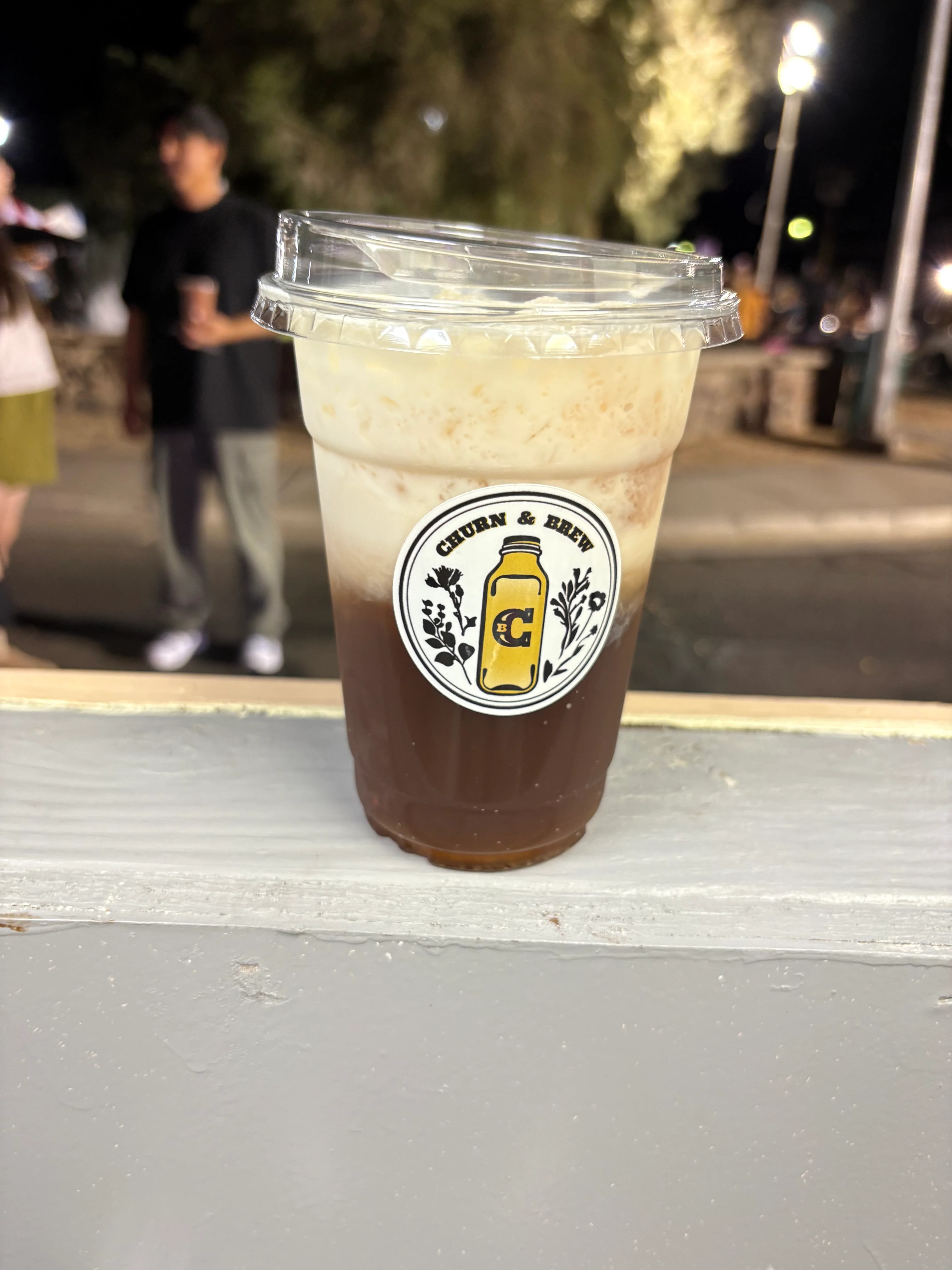 Iced coffee with cream swirling in a clear cup