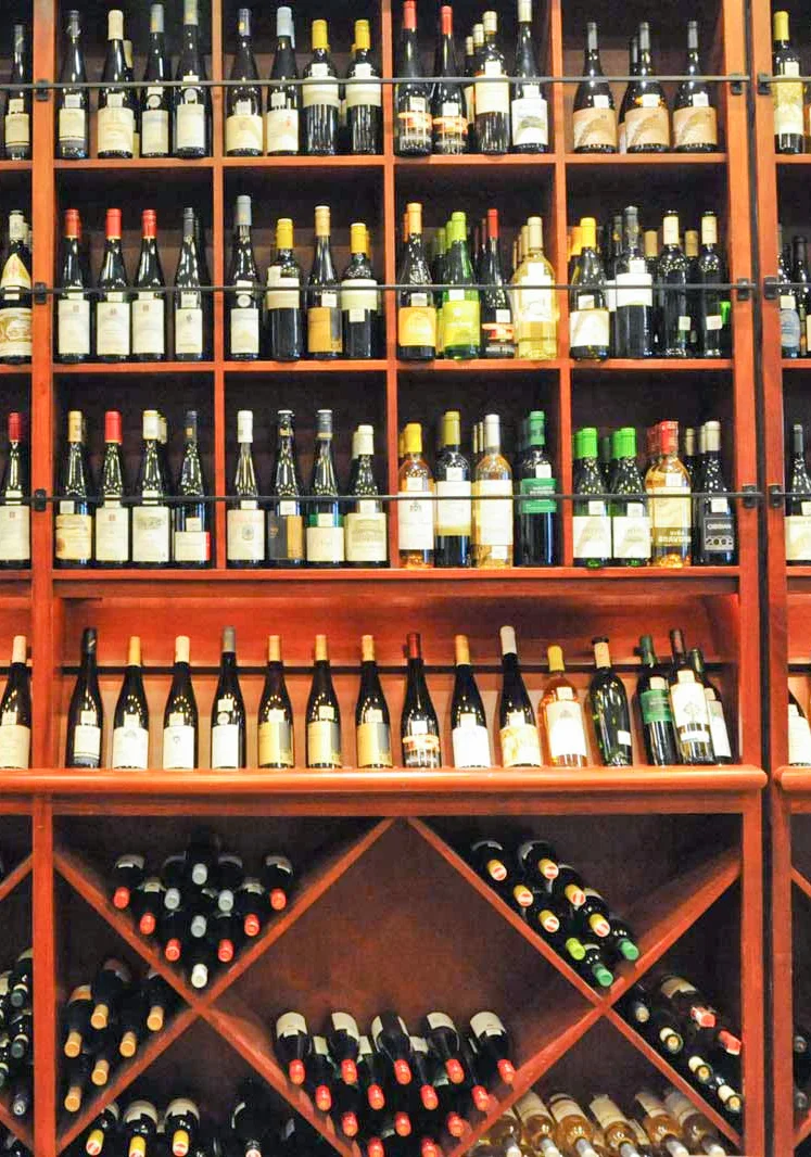 Extensive wine collection displayed on wooden shelves