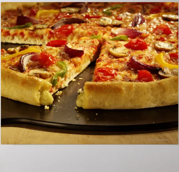 A fresh pizza topped with colorful vegetables including tomatoes, bell peppers, onions, and mushrooms, served on a black tray.