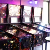 Row of vintage pinball machines in a vibrant arcade