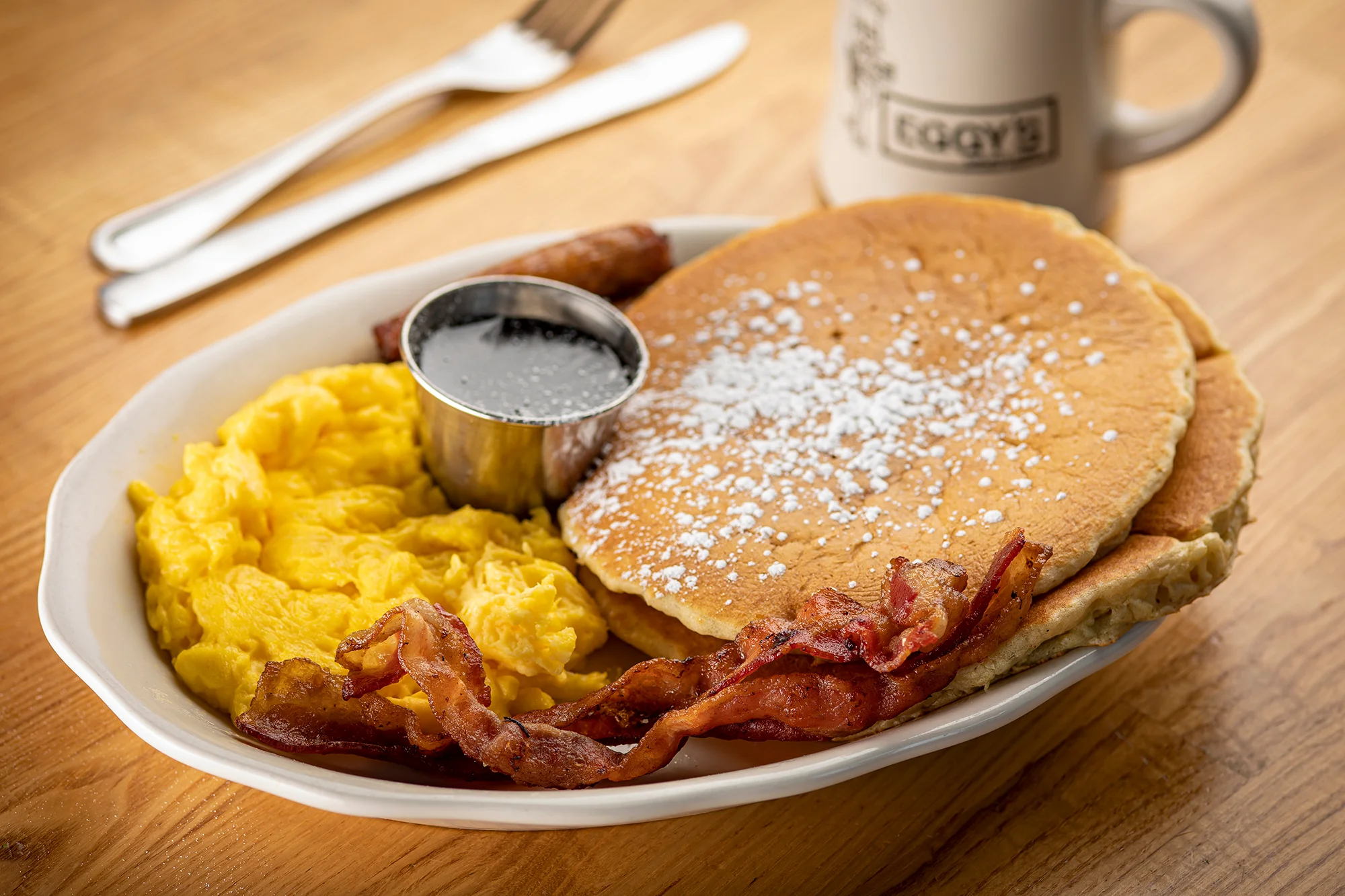 Classic American breakfast with pancakes, eggs, bacon, and sausage
