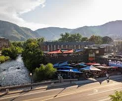 Scenic outdoor dining by a river with mountain views