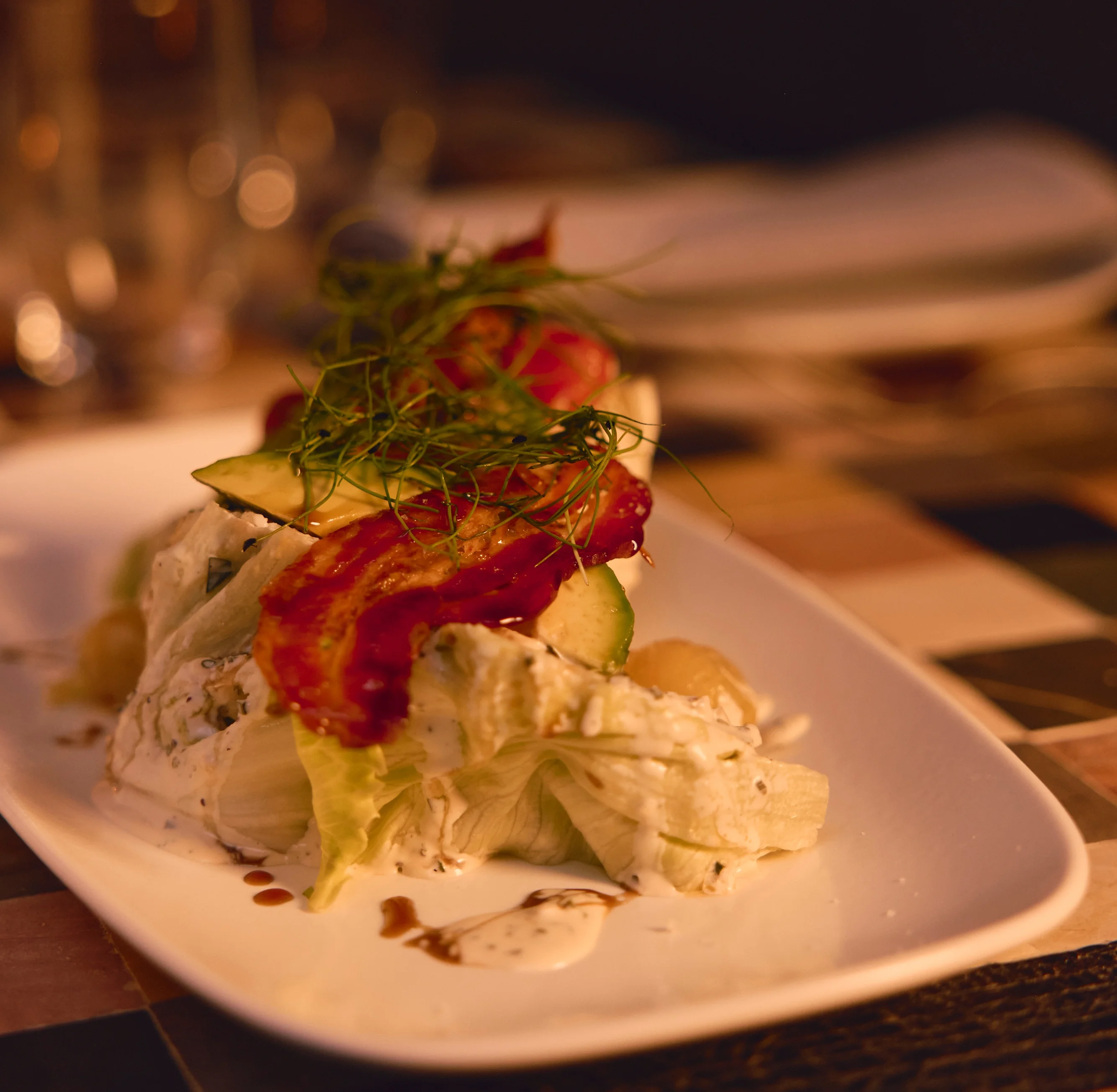 Classic wedge salad topped with crispy bacon and creamy dressing