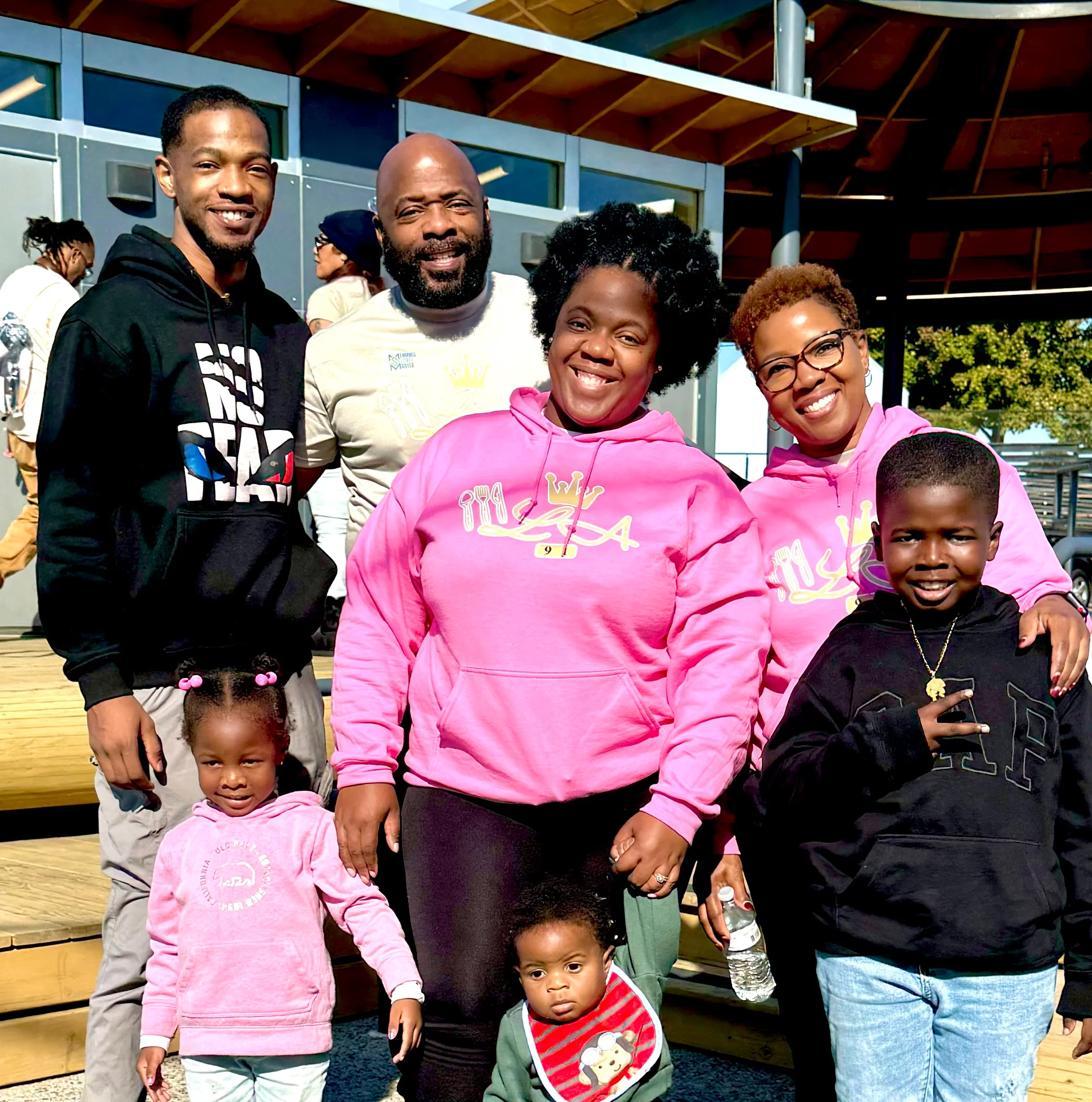 Family gathering outdoors with smiles and colorful hoodies