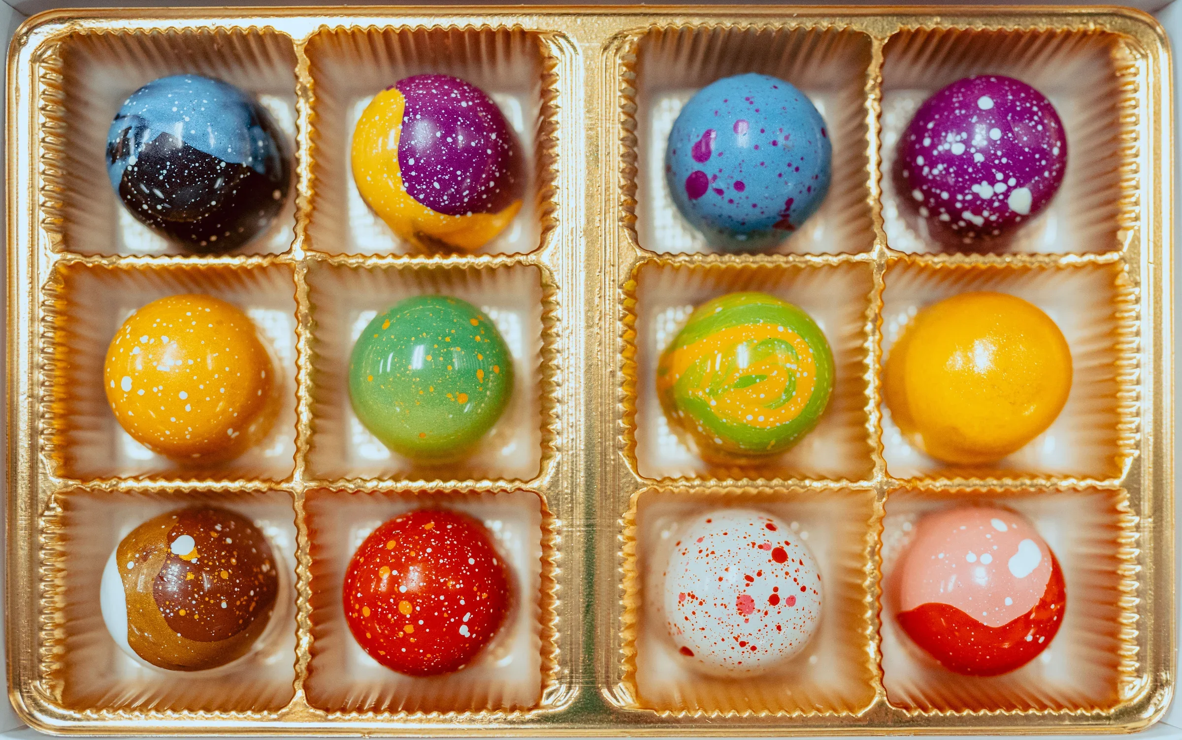 Colorful artisan chocolate bonbons in a gold box