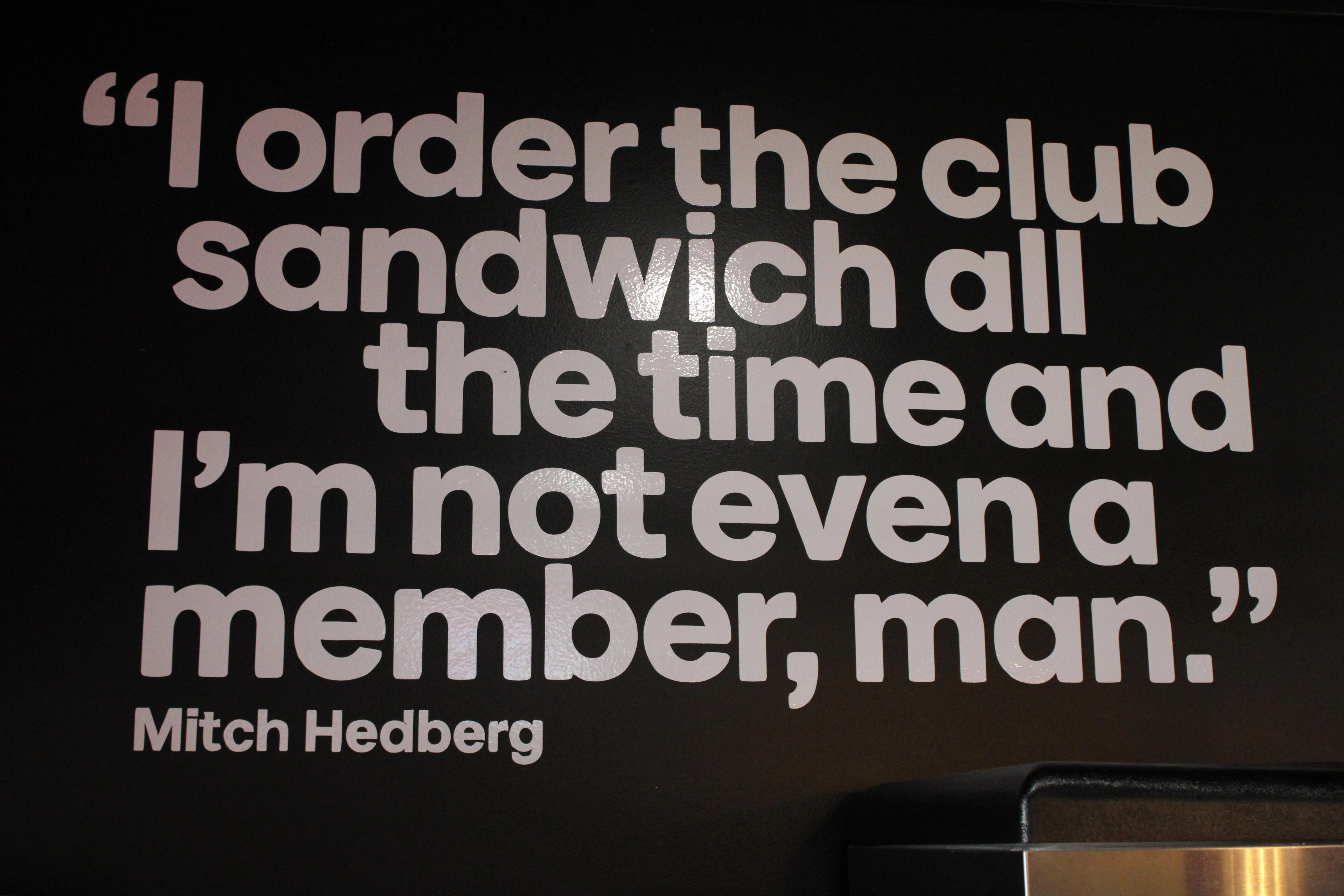 Humorous quote about club sandwiches on a restaurant wall